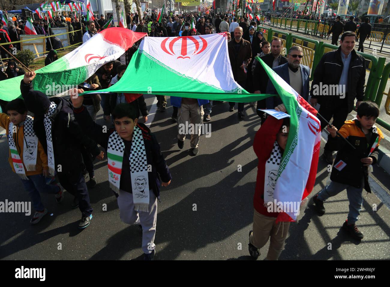 Tehran, Iran. 11th Feb, 2024. Iranian school boys wave an Iranian flag while gathering to mark the 45th anniversary of the Islamic Revolution in Tehran. Iran marked on 11 February 2024 the 45th anniversary of the 1979 Islamic Revolution amid tensions gripping the wider Middle East over Israel's continued war on Hamas in the Gaza Strip. Iranian president Ebrahim Raisi condemned arch-foe Israel and demanded it be expelled from the United Nations. (Credit Image: © Rouzbeh Fouladi/ZUMA Press Wire) EDITORIAL USAGE ONLY! Not for Commercial USAGE! Stock Photo