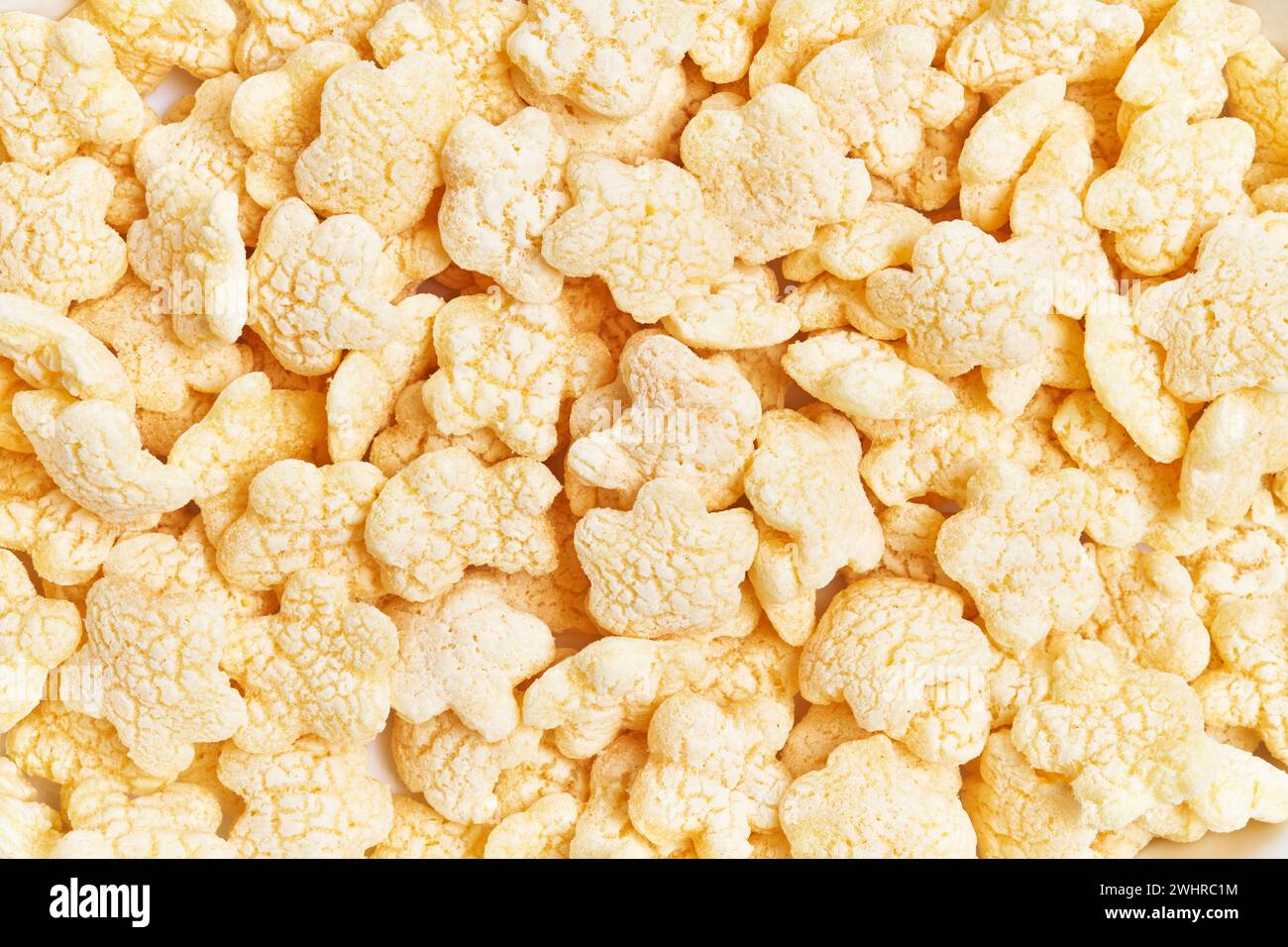 Close-up of yellow rice crisps filling the frame, representing snacks, diet, texture, and food background Stock Photo
