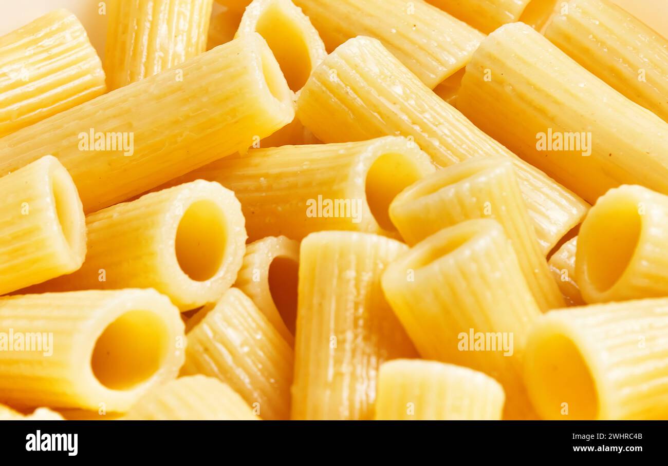 Close-up image of uncooked pasta rigatoni on a yellow background ...