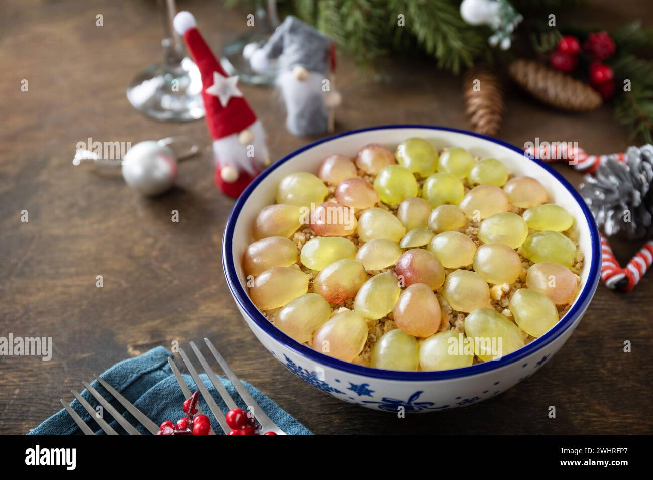 Winter Christmas salad. Delicious salad with chicken, cheese, walnuts and grapes on a festive table. Copy space. Stock Photo