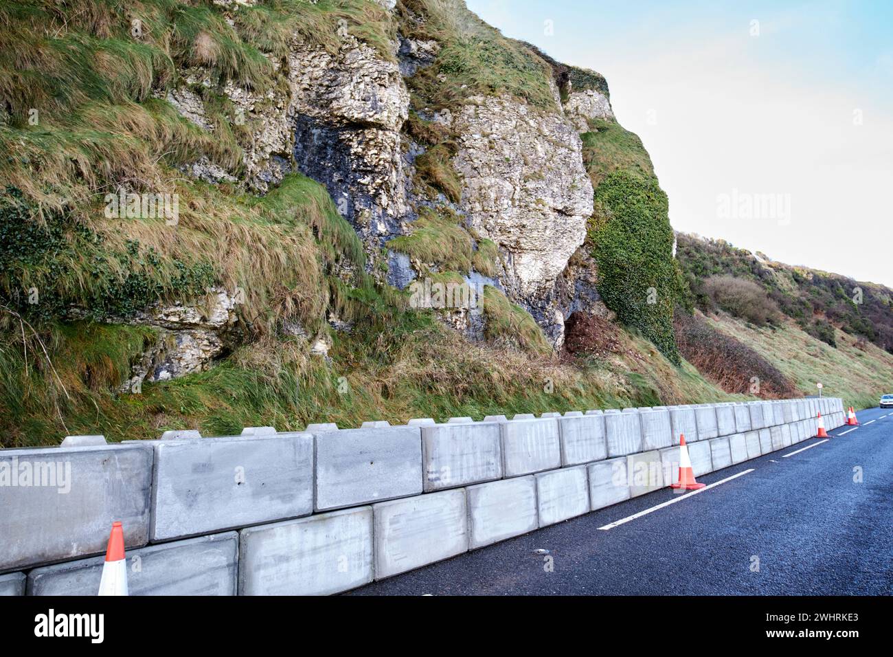 reduced lane and barriers due to cliff erosion landslide on the antrim coast road between larne and drains bay county antrim northern ireland uk Stock Photo