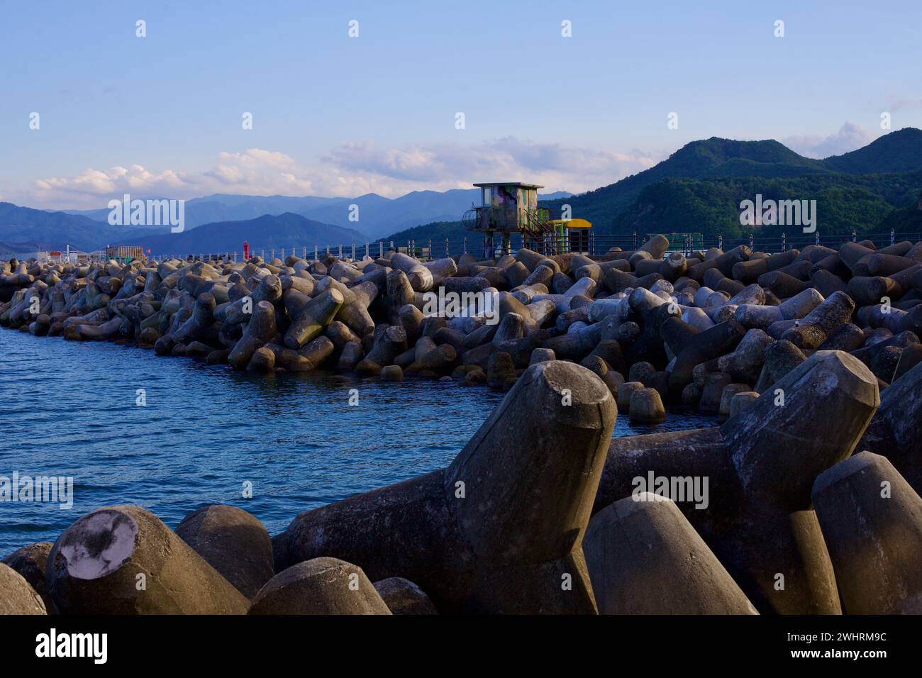 Gangneung City, South Korea - July 29th, 2019: A breakwater formed by concrete tetrapods at Geumjin Port features a military lookout post, captured ne Stock Photo