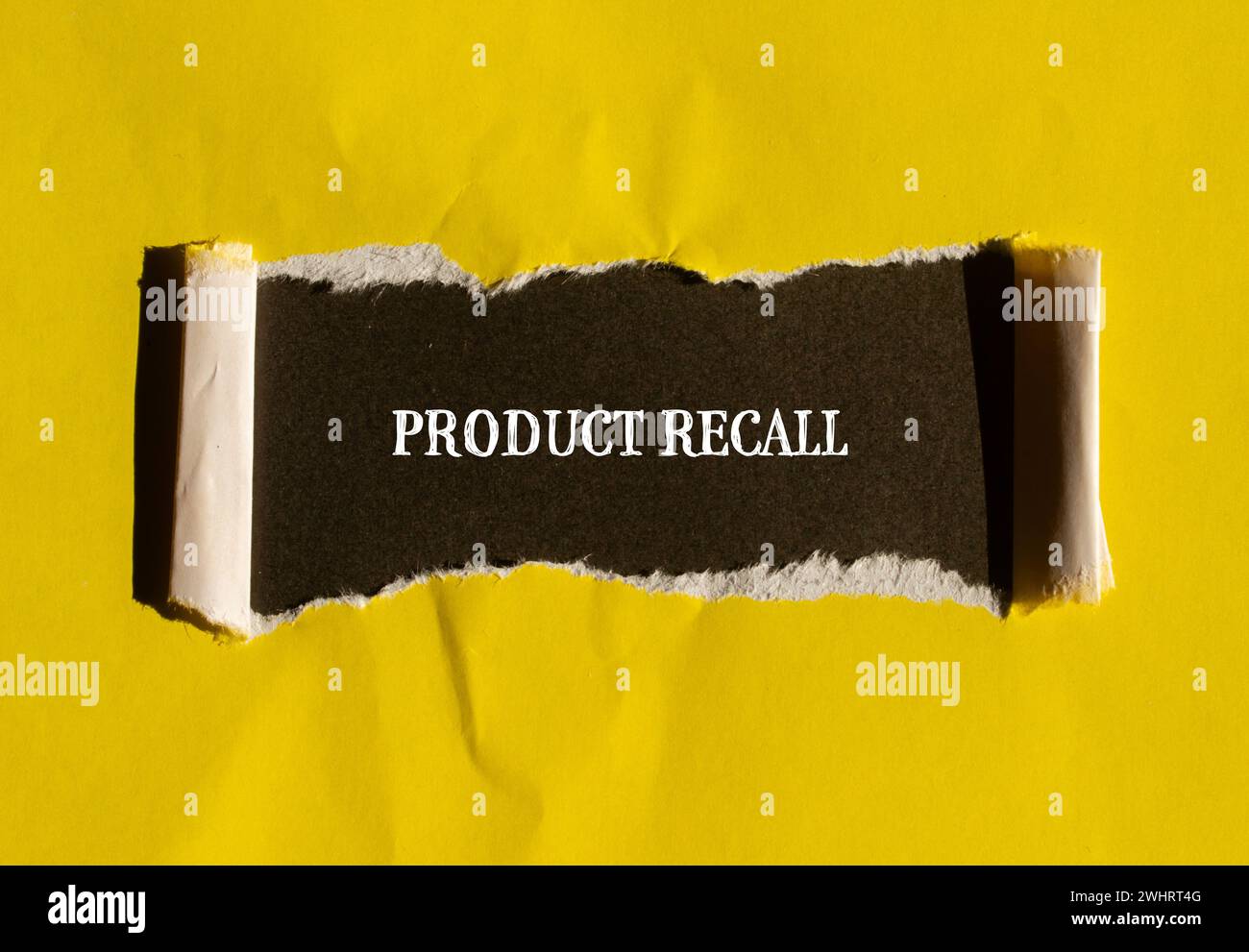 Product recall words written on torn yellow paper with black background. Conceptual business symbol. Copy space. Stock Photo