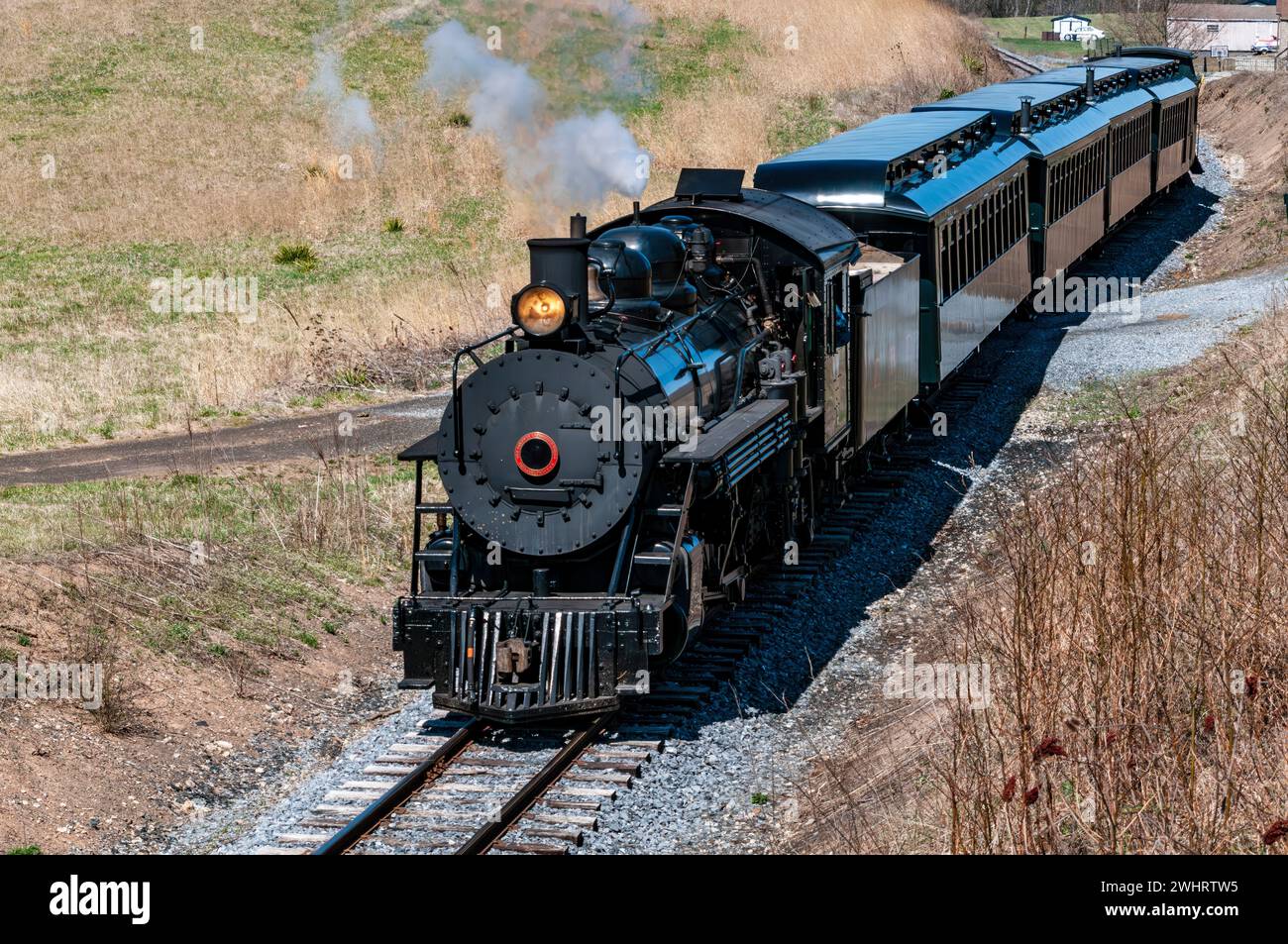 Front and Above View of an Approaching Restored Narrow Gauge Passenger Steam Train Blowing Smoke Stock Photo