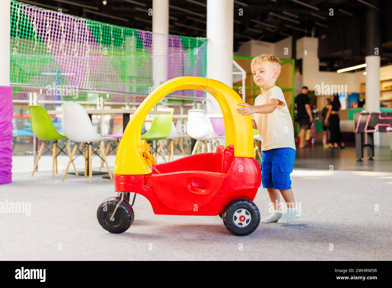 Toddler Playing with Toy Car in Playroom Stock Photo - Alamy