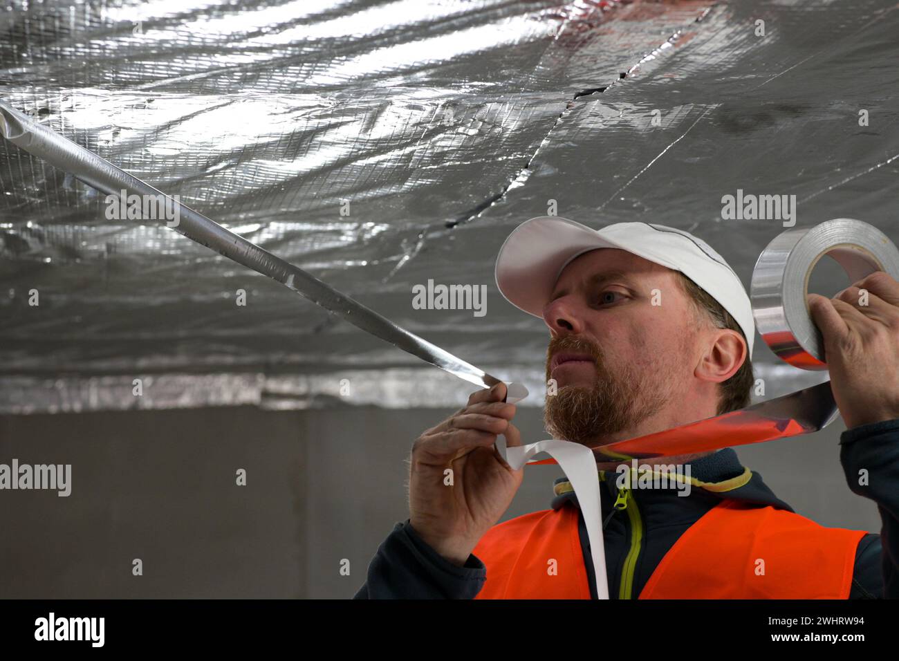the construction worker uses aluminum tape and they had a roller for ...