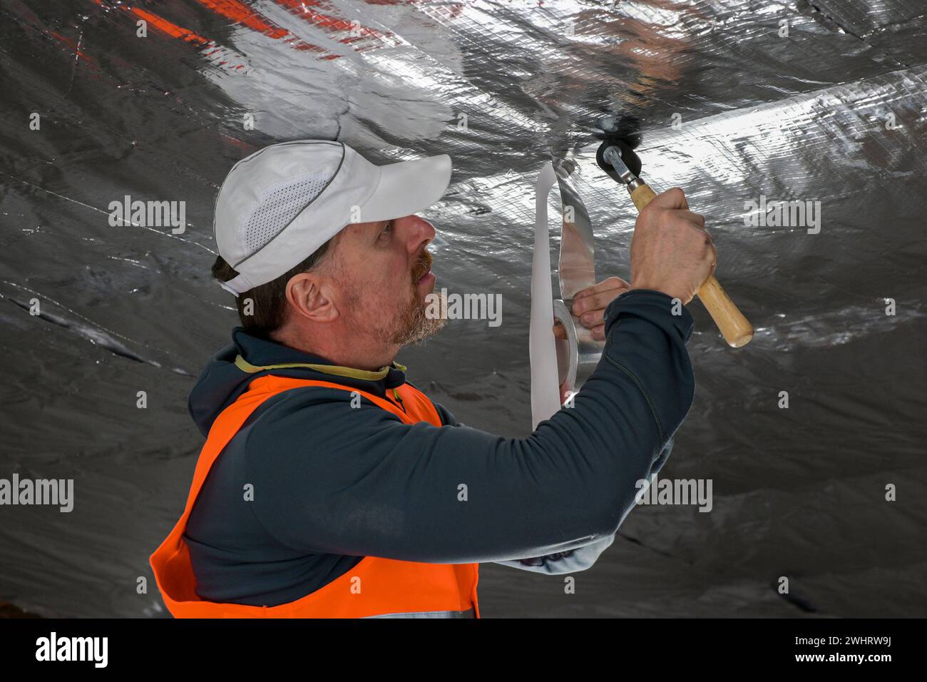 the construction worker uses aluminum tape and they had a roller for ...