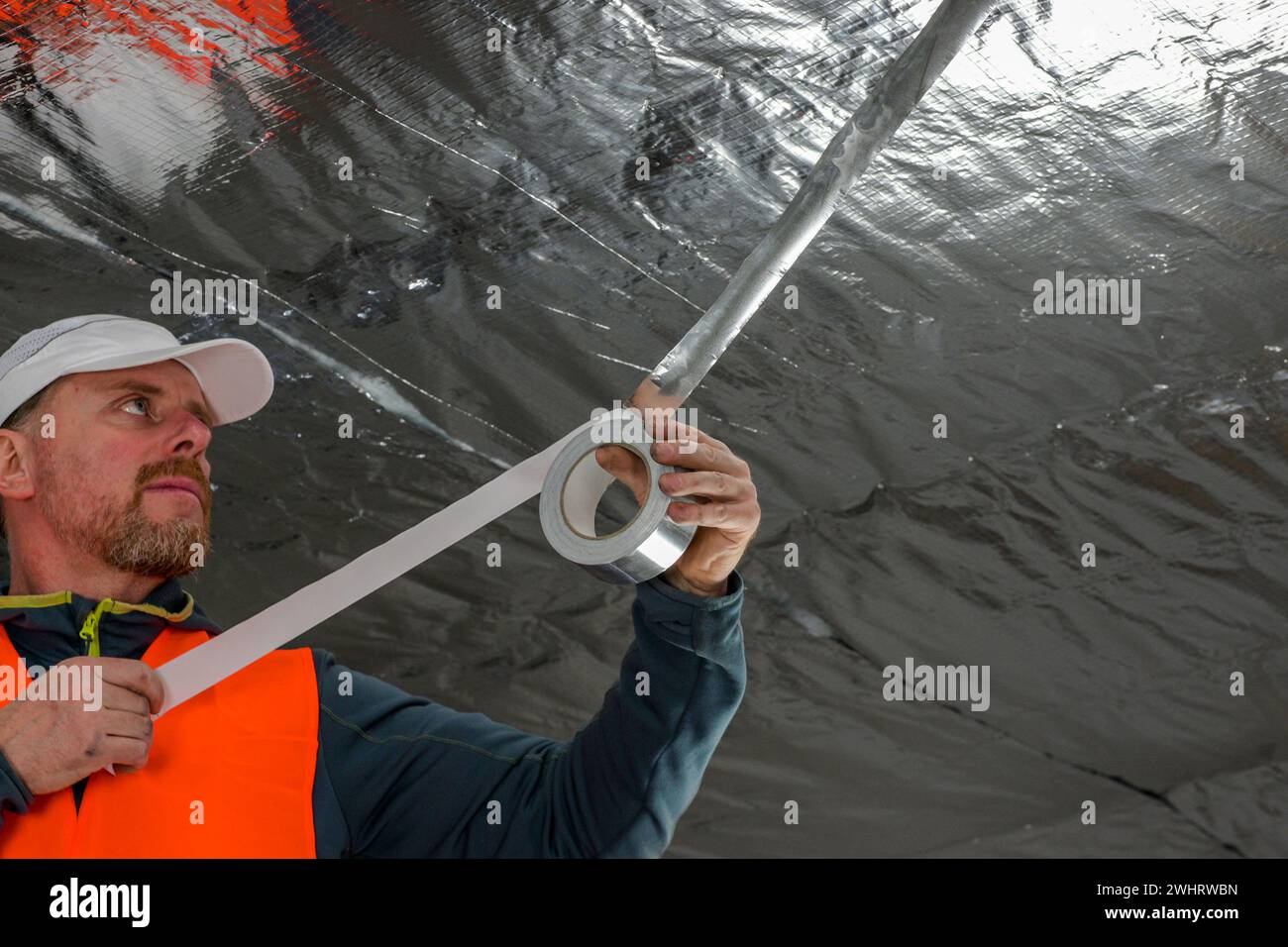 the construction worker uses aluminum tape and they had a roller for ...