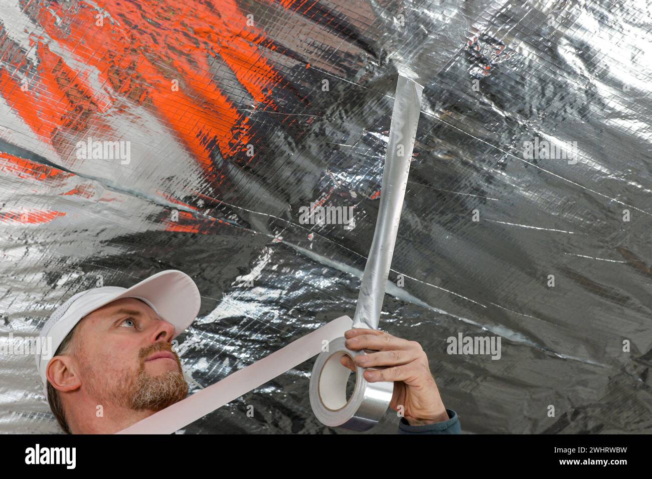 the construction worker uses aluminum tape and they had a roller for ...