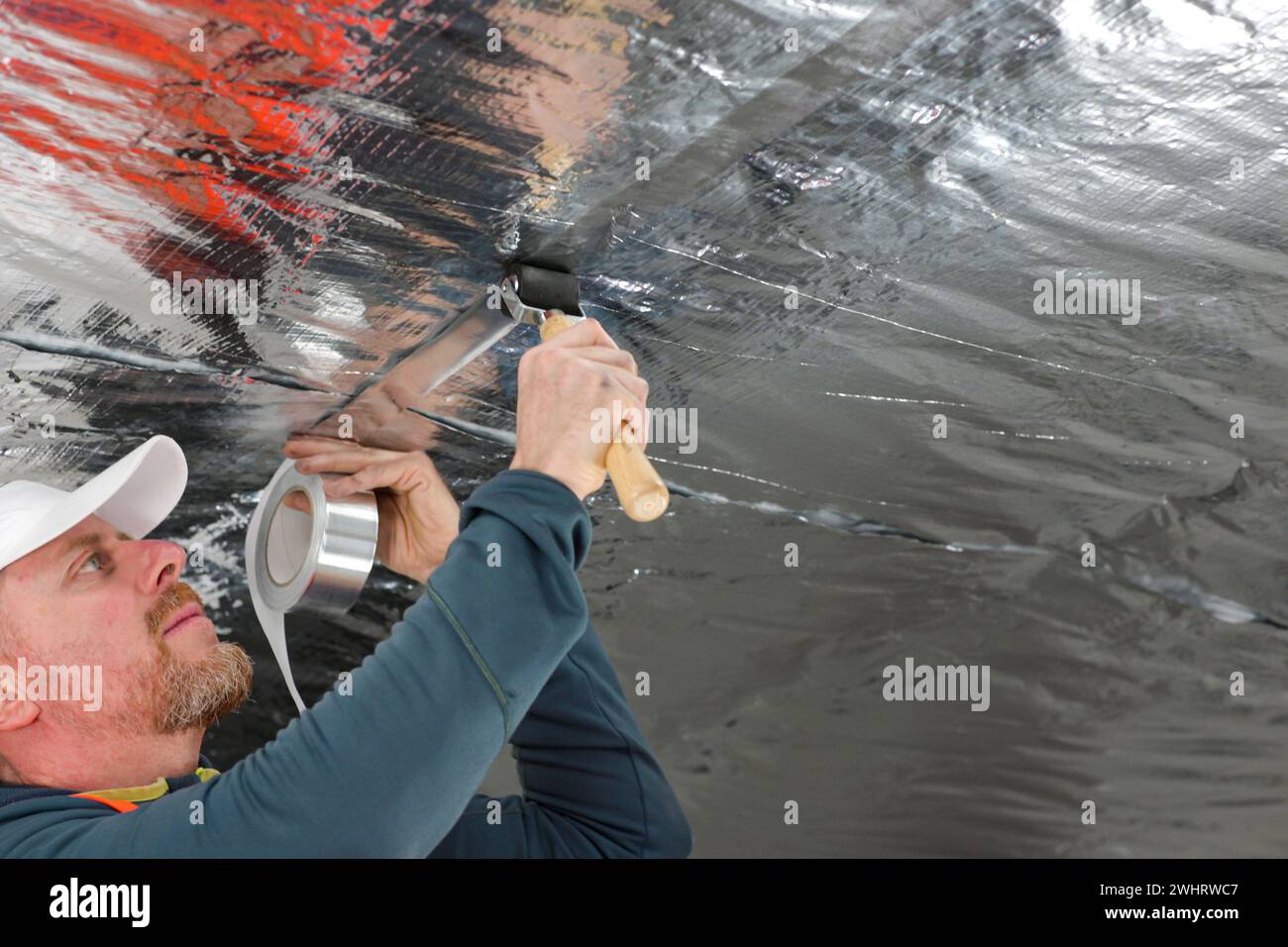 the construction worker uses aluminum tape and they had a roller for ...