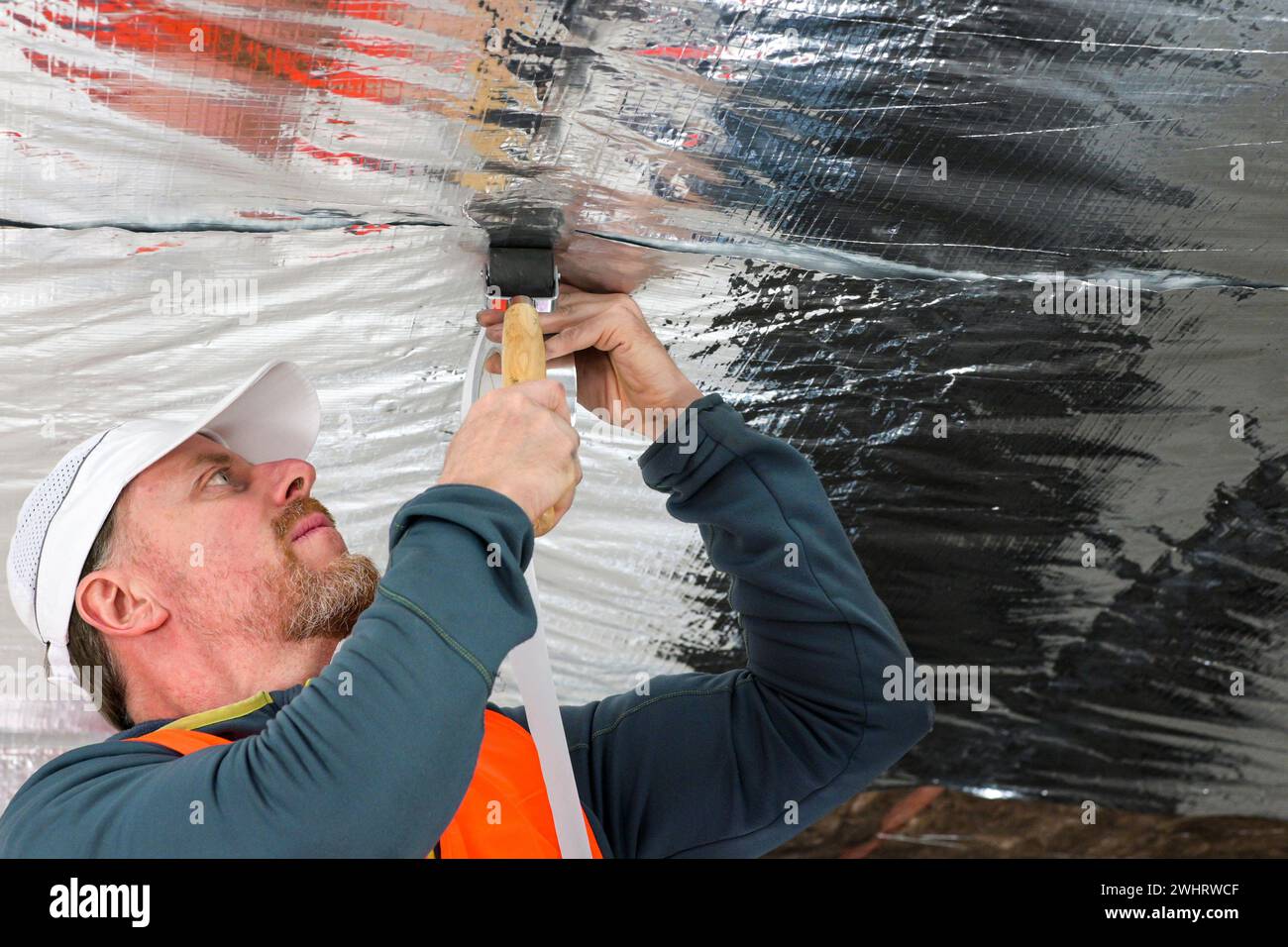 the construction worker uses aluminum tape and they had a roller for ...
