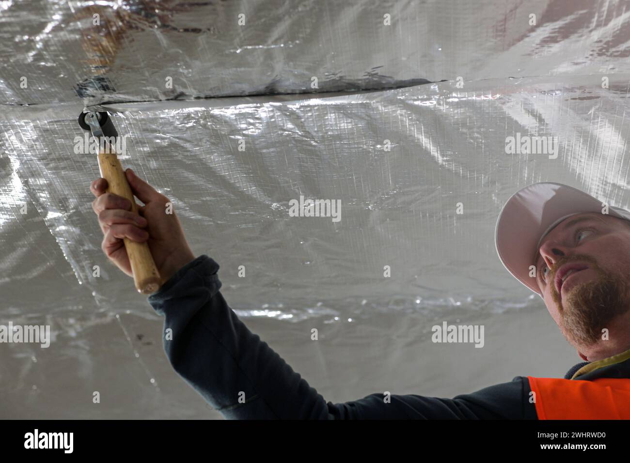 the construction worker uses aluminum tape and they had a roller for ...