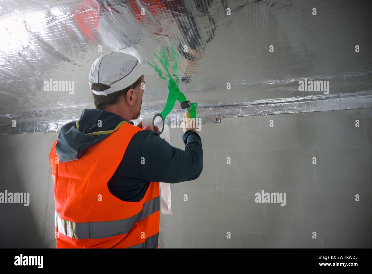 the construction worker uses aluminum tape and they had a roller for ...