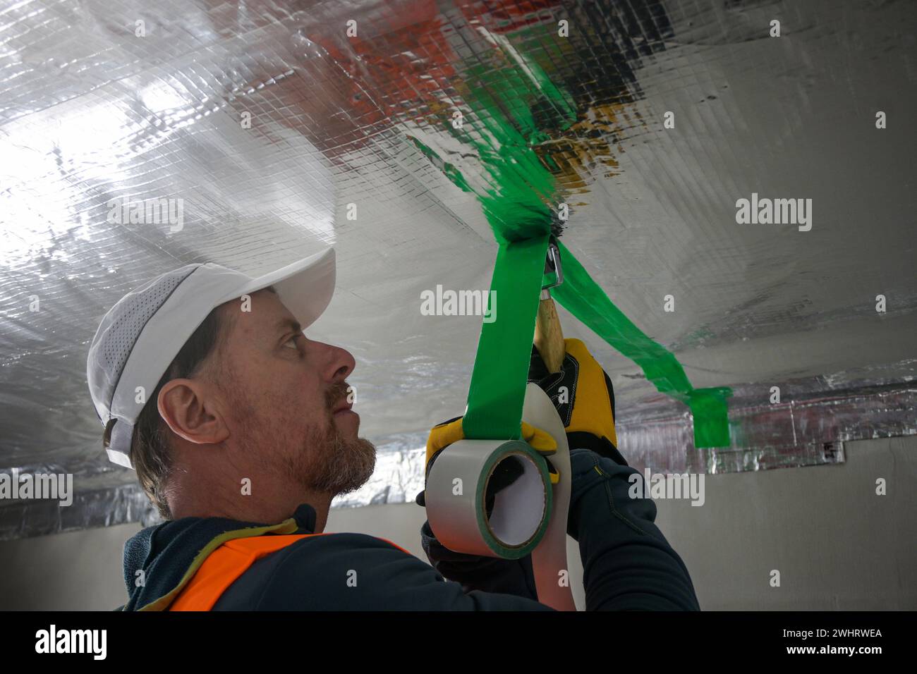 the construction worker uses aluminum tape and they had a roller for ...