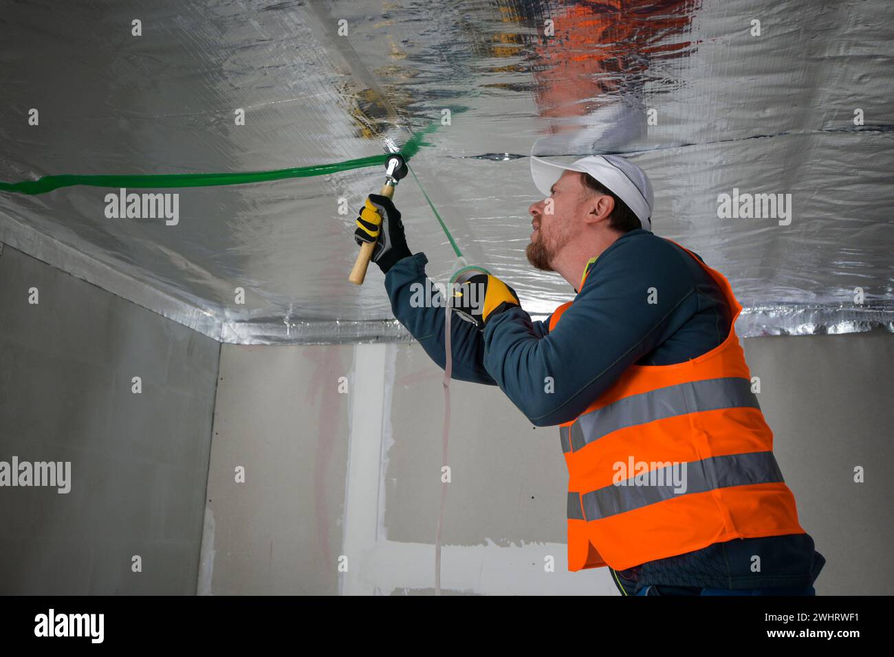the construction worker uses aluminum tape and they had a roller for ...