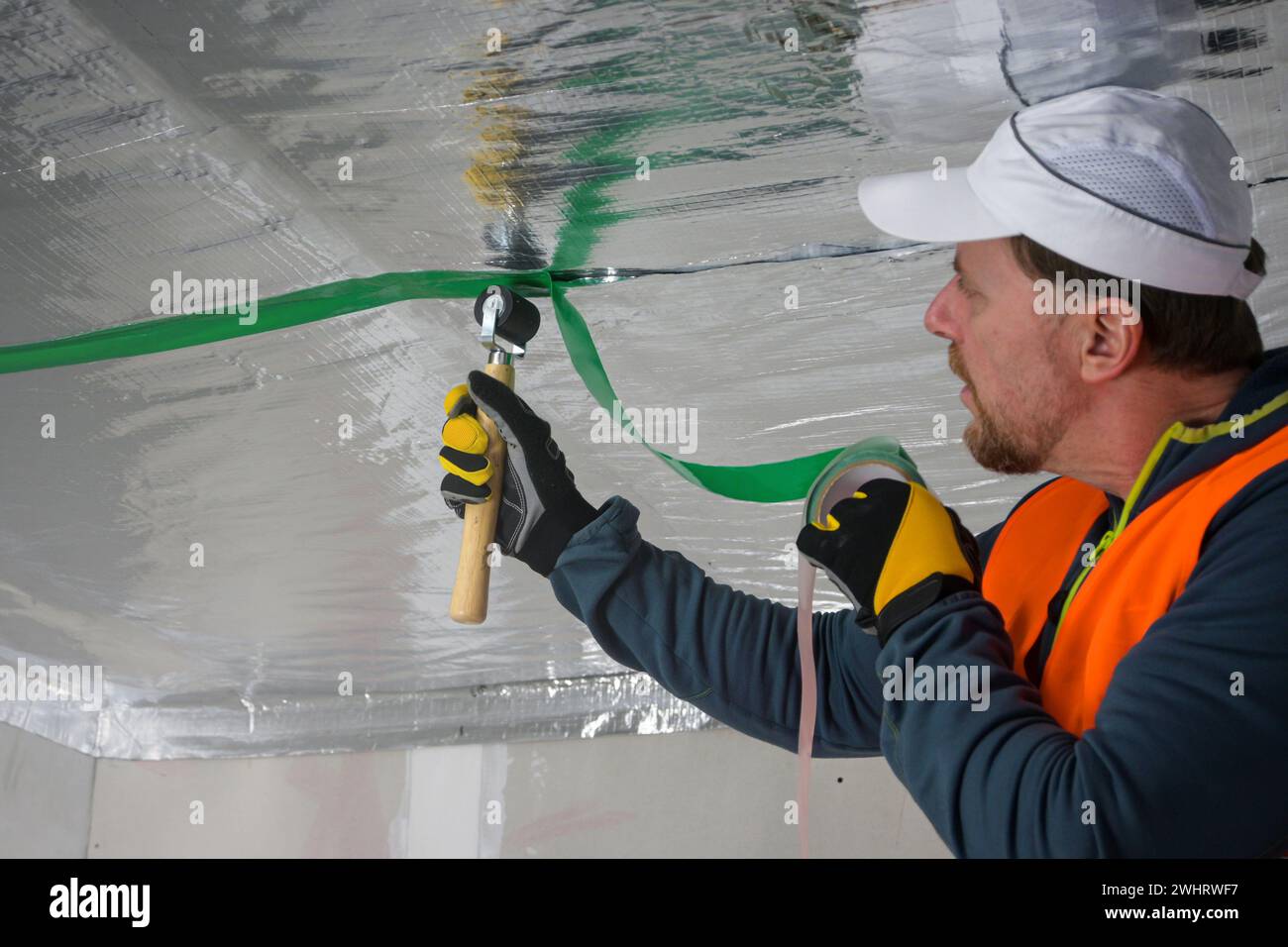 the construction worker uses aluminum tape and they had a roller for ...