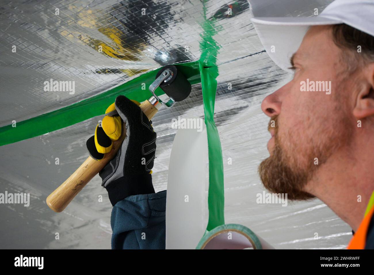 the construction worker uses aluminum tape and they had a roller for ...