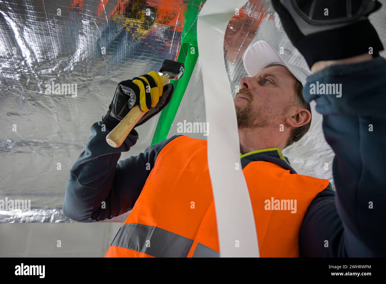 the construction worker uses aluminum tape and they had a roller for ...
