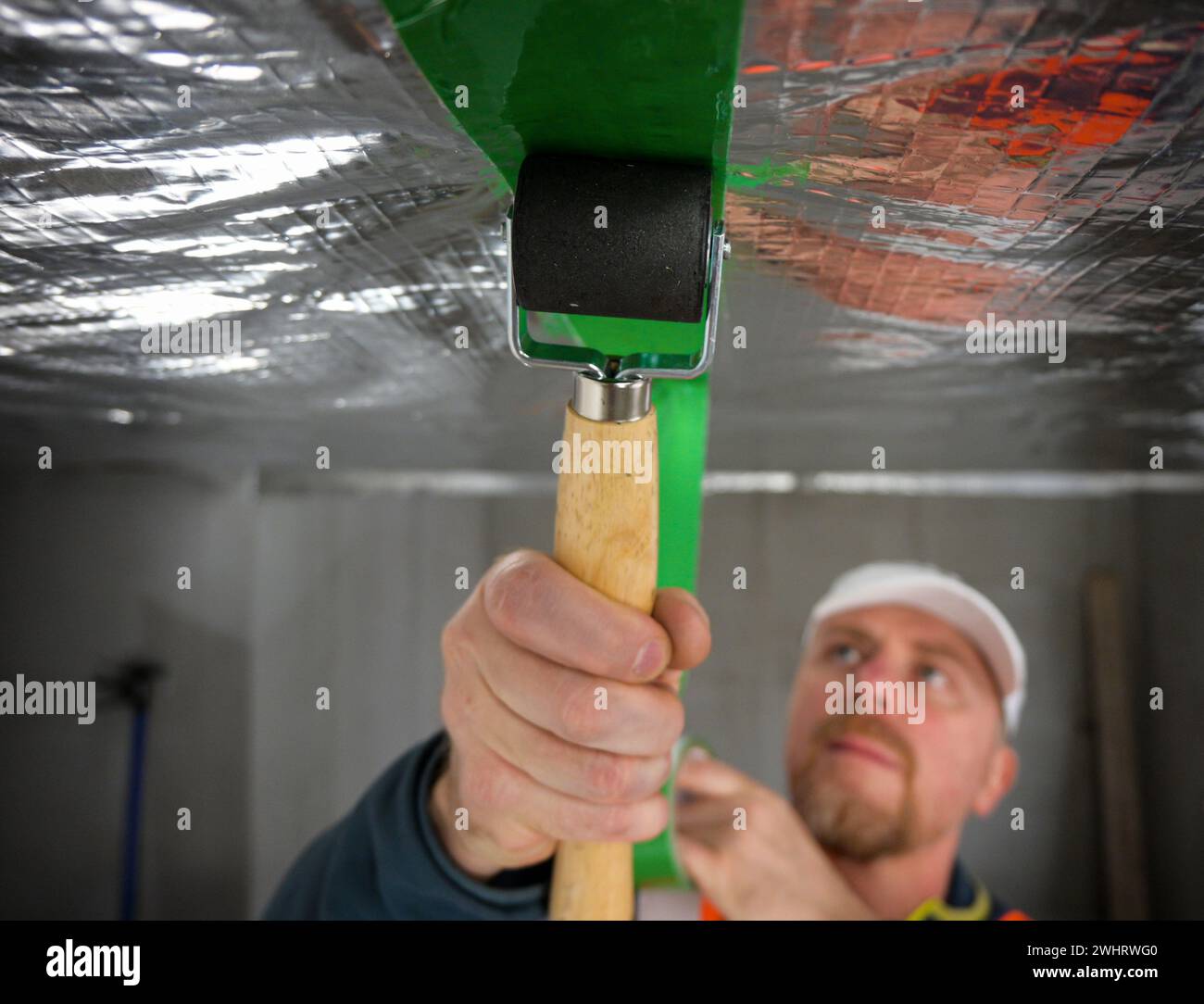 the construction worker uses aluminum tape and they had a roller for ...