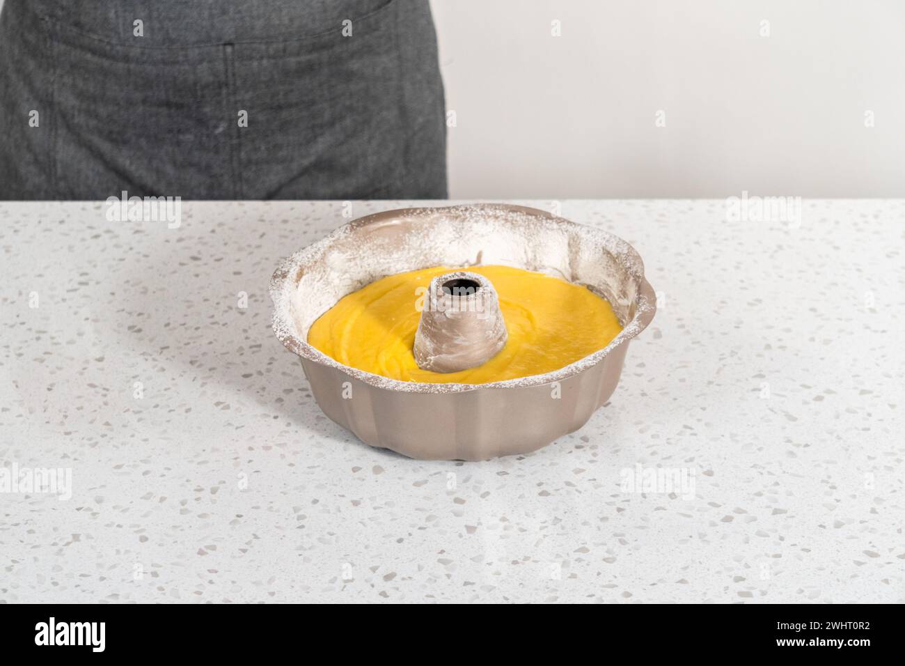 Pouring cake batter into a greased bunt cake pan to bake a simple