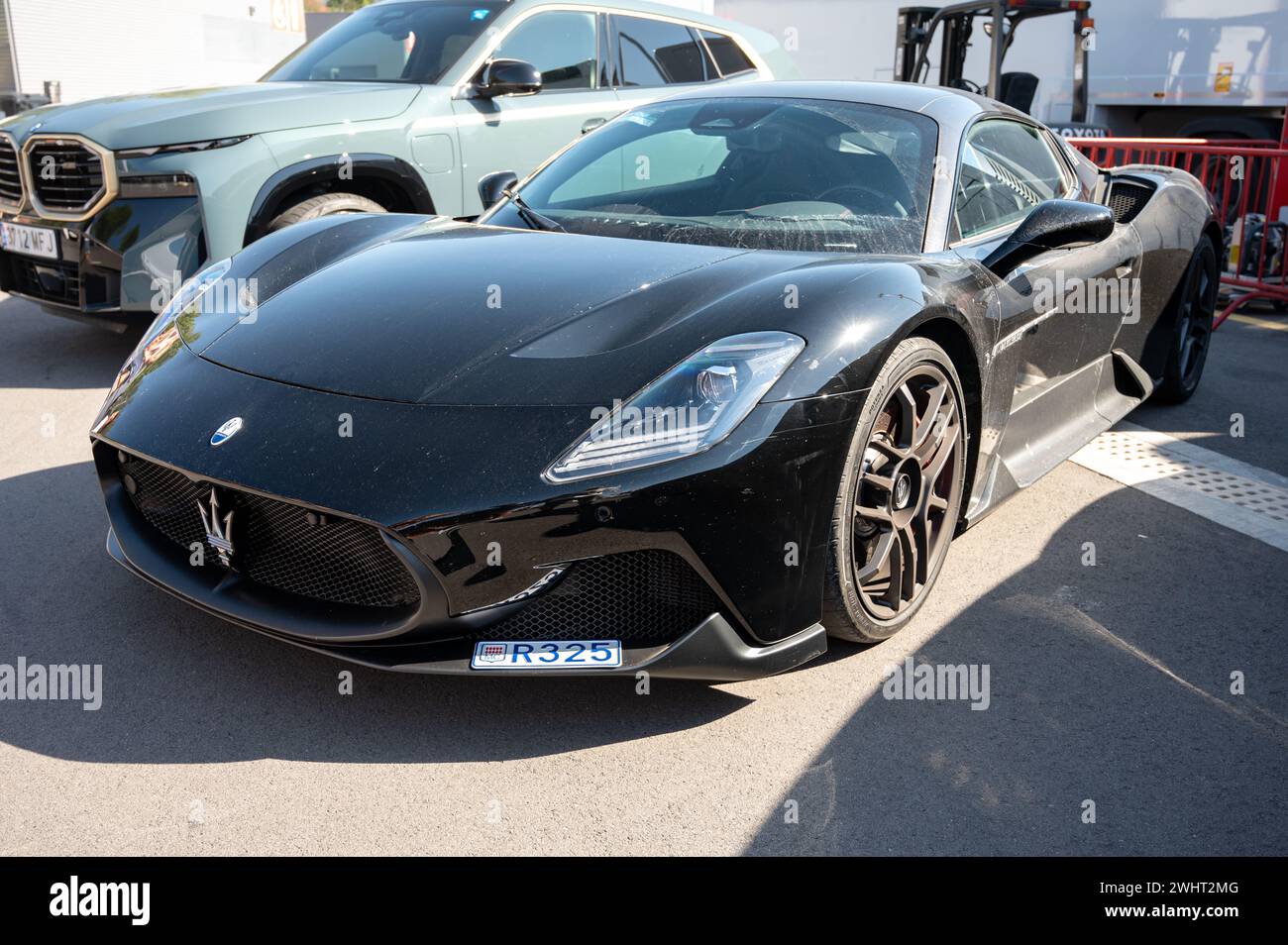 Front view of an impressive and exclusive black Maserati MC20 Italian sports car, it is a little dusty Stock Photo