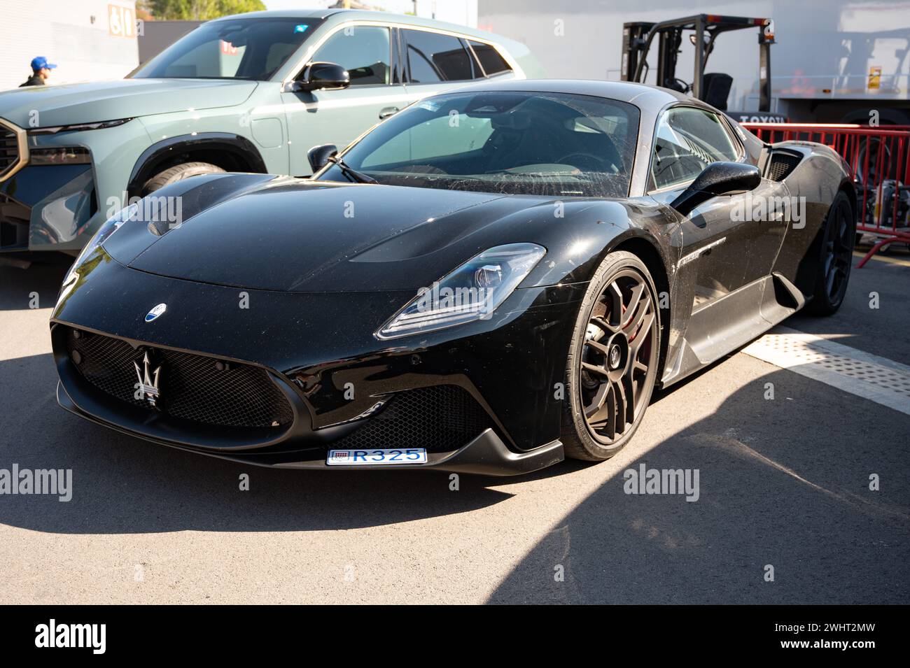 Front view of an impressive and exclusive black Maserati MC20 Italian sports car, it is a little dusty Stock Photo