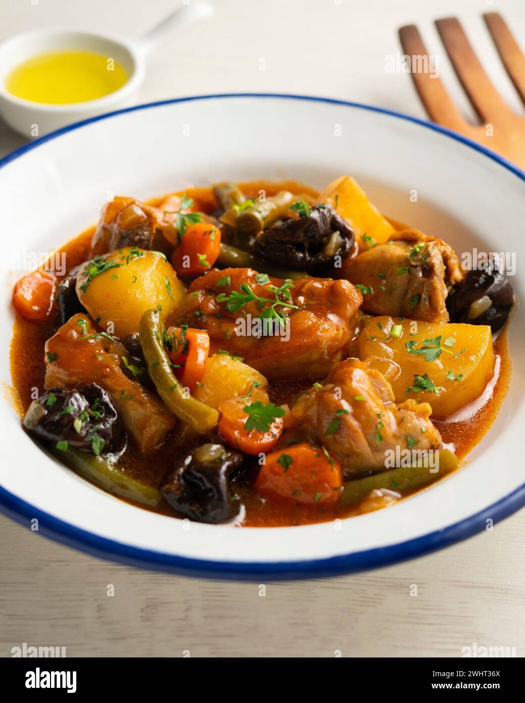 Stewed rabbit with potatoes, green beans, carrots and tomato. Stock Photo
