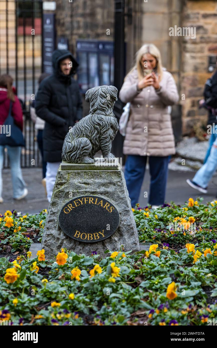 Tourist taking photo of Greyfriar's Bobby dog statue, Greyfriar's kirkyard, Edinburgh, Scotland, UK Stock Photo