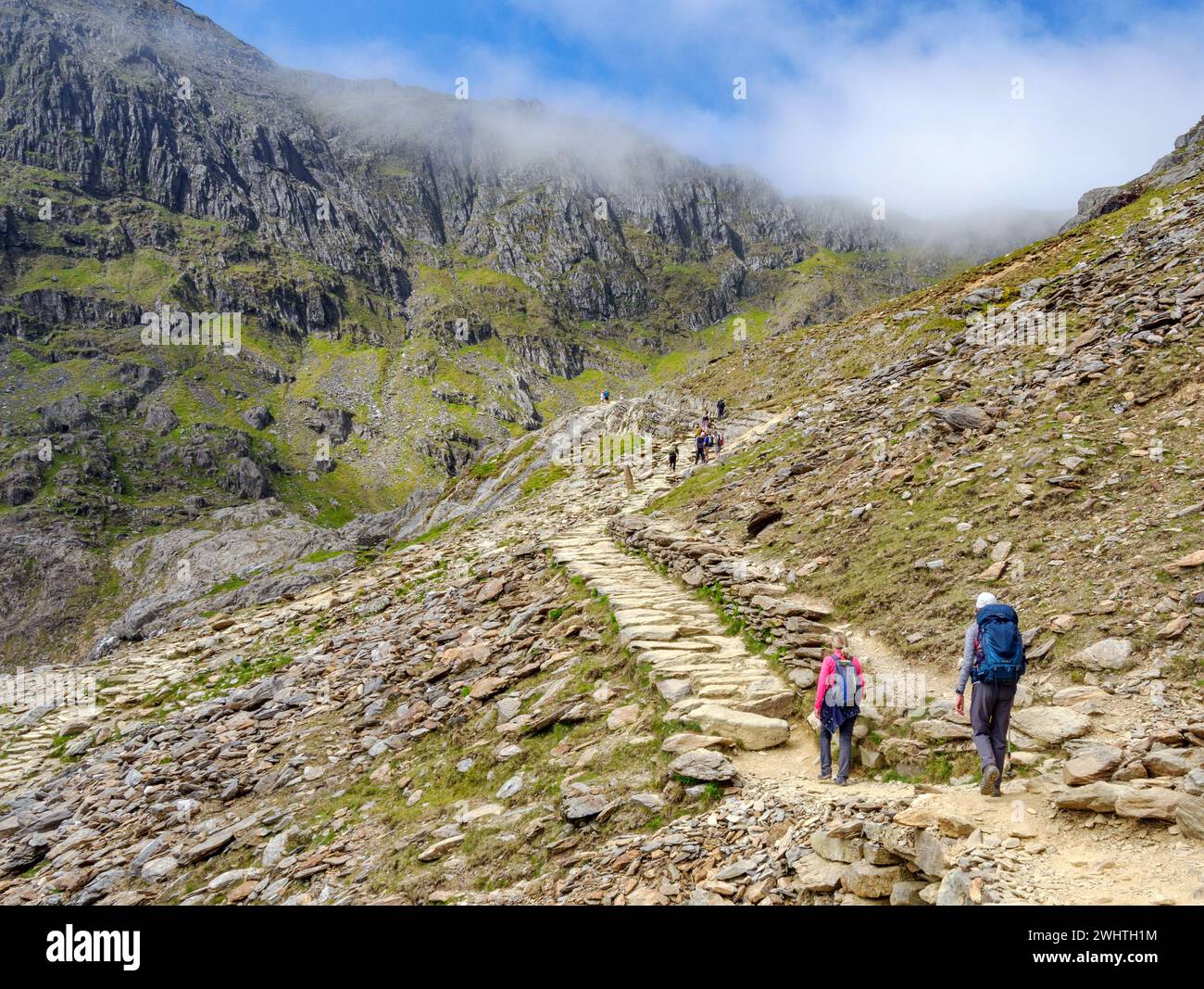 Walkers ascending the Pyg Track a popular route towards the summit ridge of Yr Wyddfa Snowdon in the Snowdonia National Park North Wales Stock Photo
