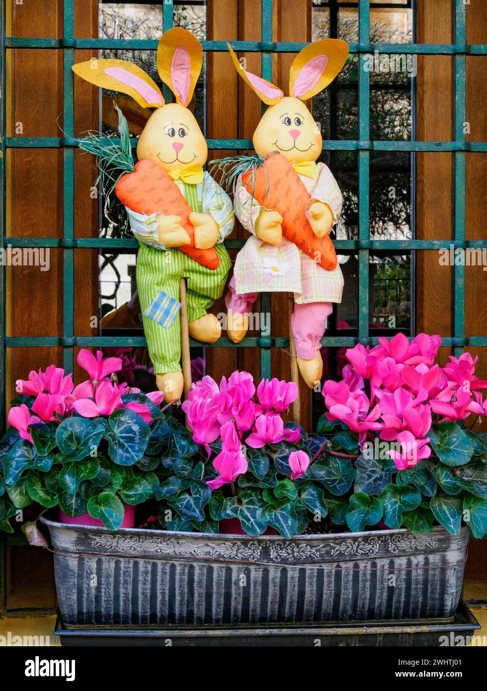 Window of a house in Majorca Spain decorated with Easter bunnies and a window box filled with pink cyclamen flowers Stock Photo
