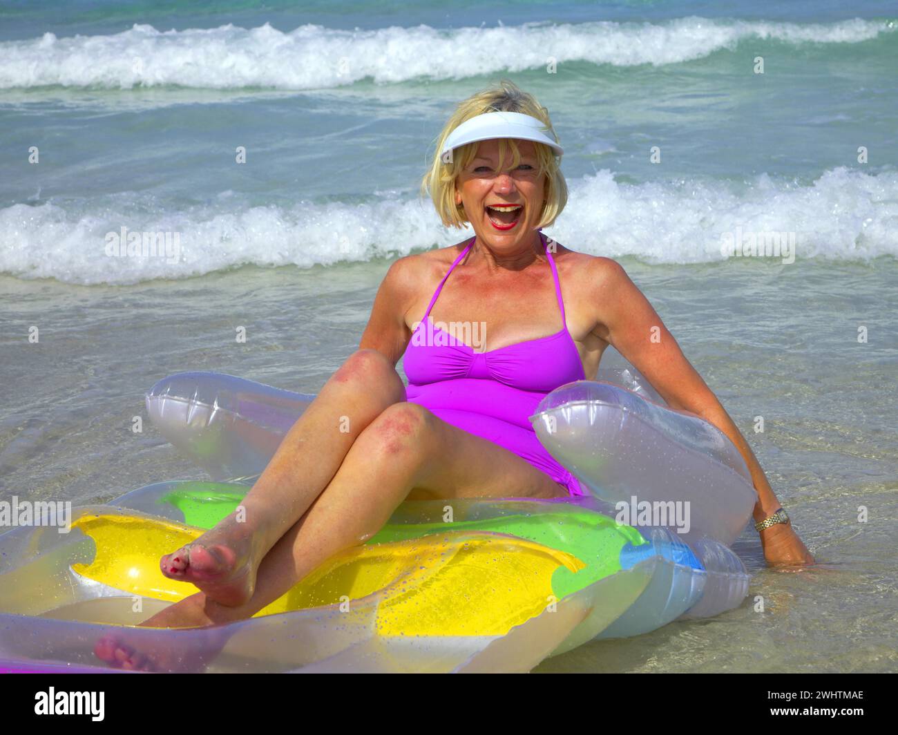 Senior citizen, woman with air mattress on the beach in Ibiza Stock Photo