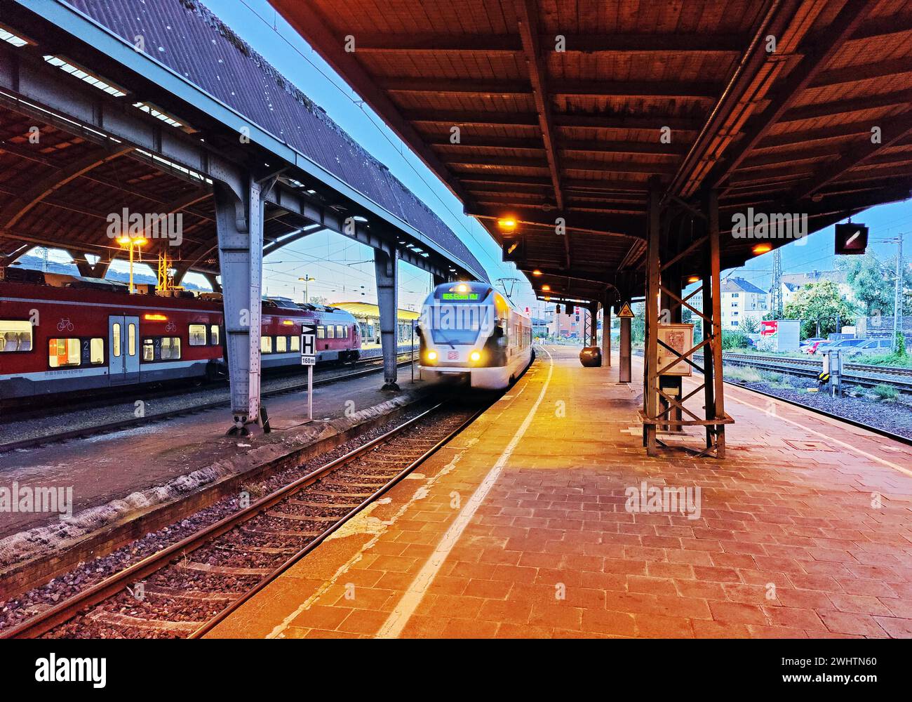 Deserted platform with arriving train in the evening, main station, Hagen, North Rhine-Westphalia, Germany Stock Photo