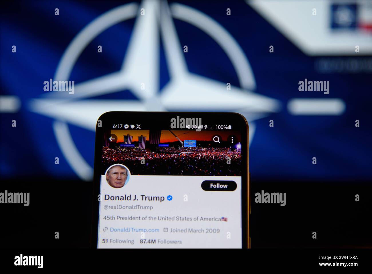U.S.A and NATO Illustrations. Former president of the United States of America Donald Trump account on the social media platform X is pictured on a smartphone screen before a NATO logo on February 11, 2024 in Warsaw, Poland. Warsaw Poland Copyright: xAleksanderxKalkax Stock Photo