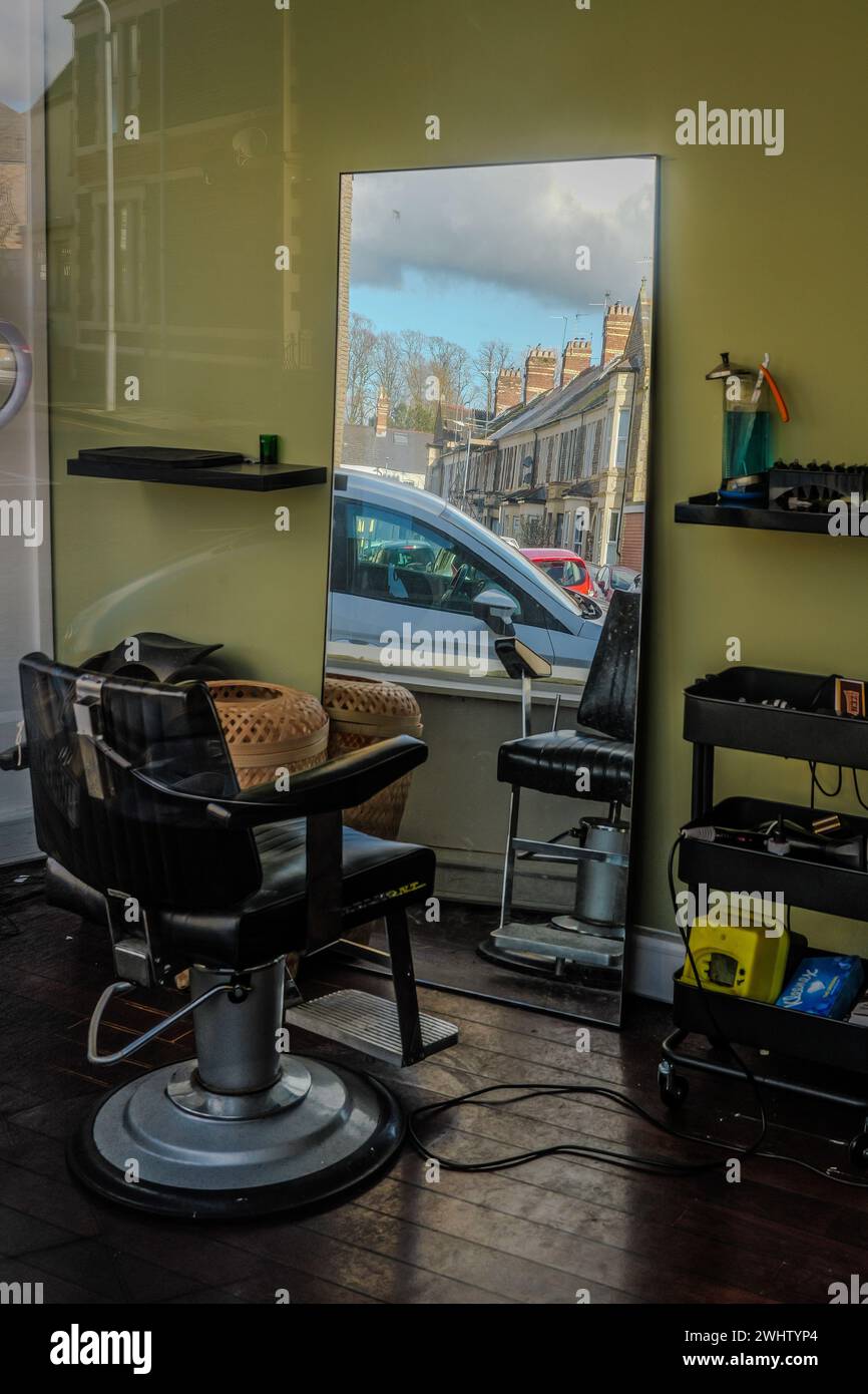 Abstract reflection of Edwardian houses in a mirror inside an empty barber's shop with barber's chair. Quirky. Concept - seeing through reflections. Stock Photo