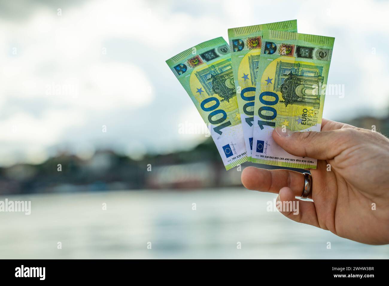 July 21, 2023: Hand holding three one hundred euro banknotes *** Hand hält drei Einhundert Euro Geldscheine Stock Photo