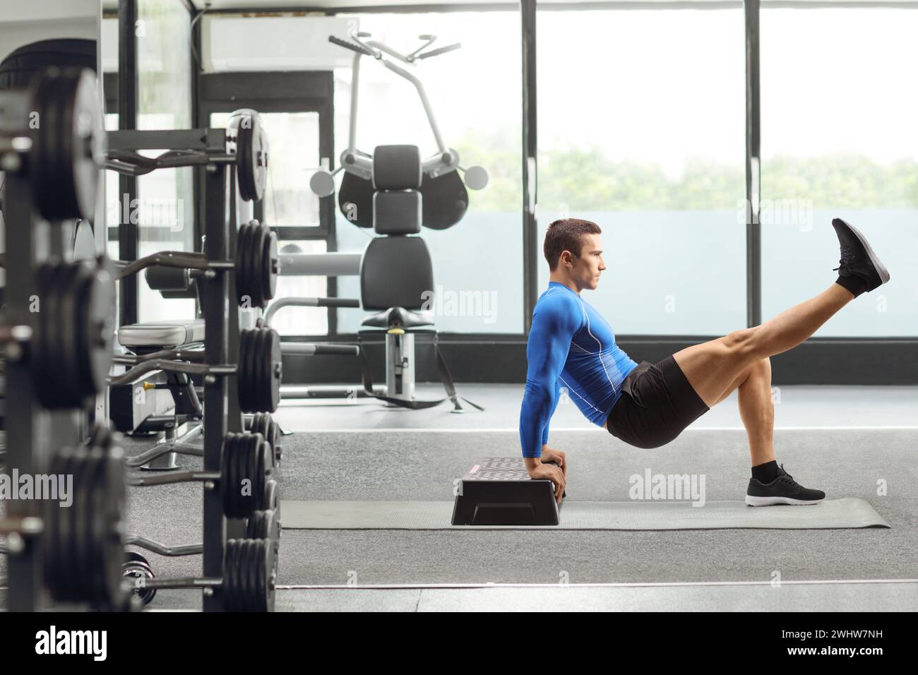 Full length portrait of a fit man exercising on a stepper at a gym Stock Photo