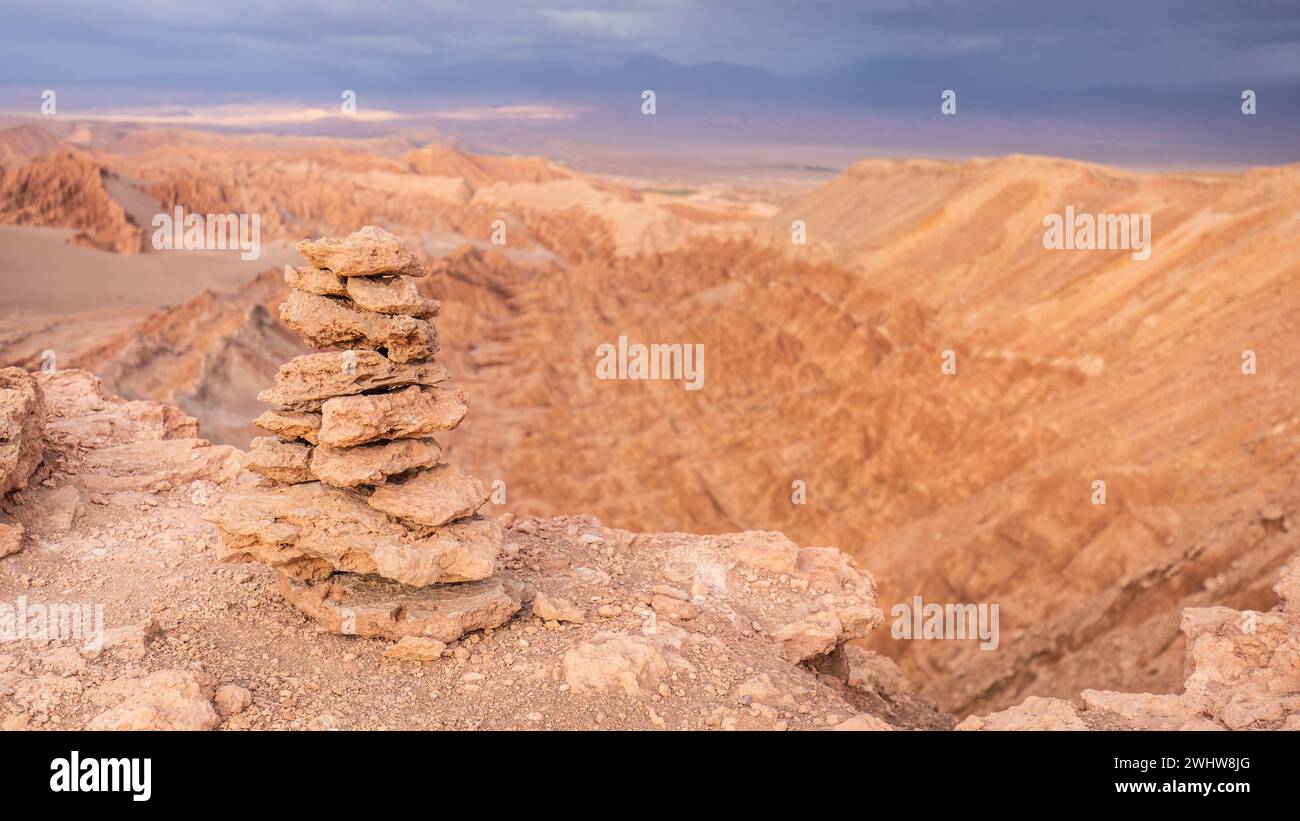 A pile of stones above the red rocks and rock formations of the Valle de la Muerte, Valley of Mars, in the Atacama Desert at sunset. Stock Photo