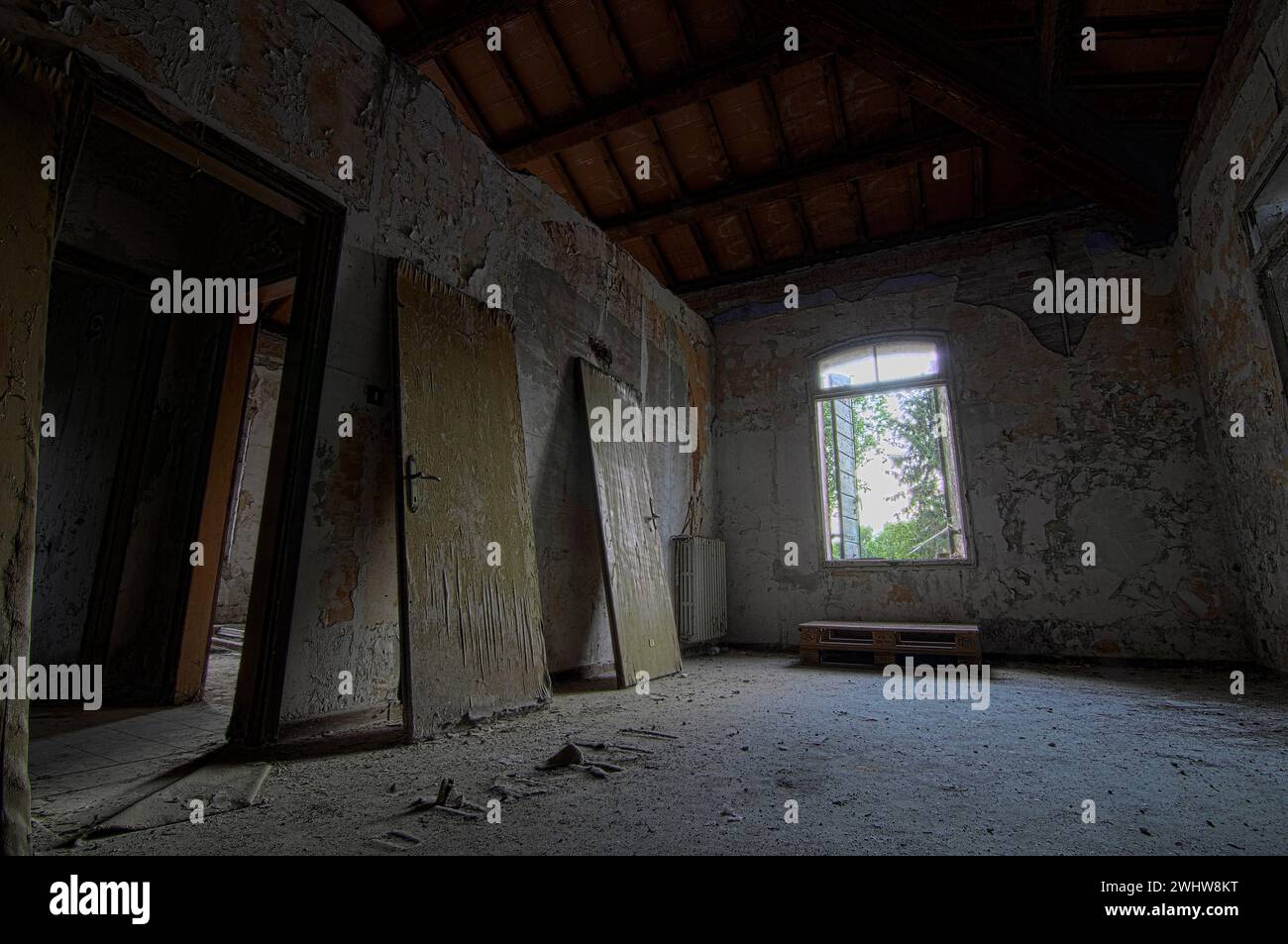 View of empty room with dismantled doors leaning against the wall in uninhabited house Stock Photo
