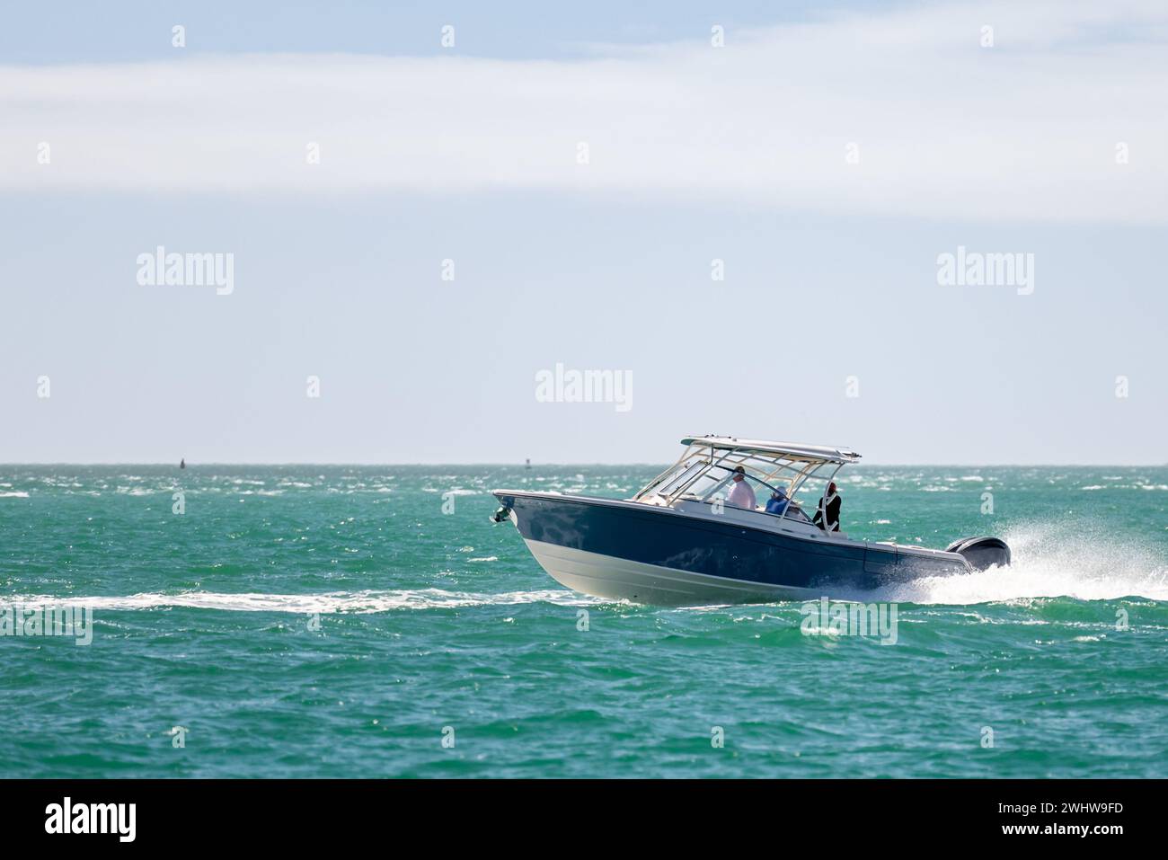 Saltwater fishing boat on a sunny summer day. People on recreational power boat cruising the Gulf of Mexico, Florida. Stock Photo