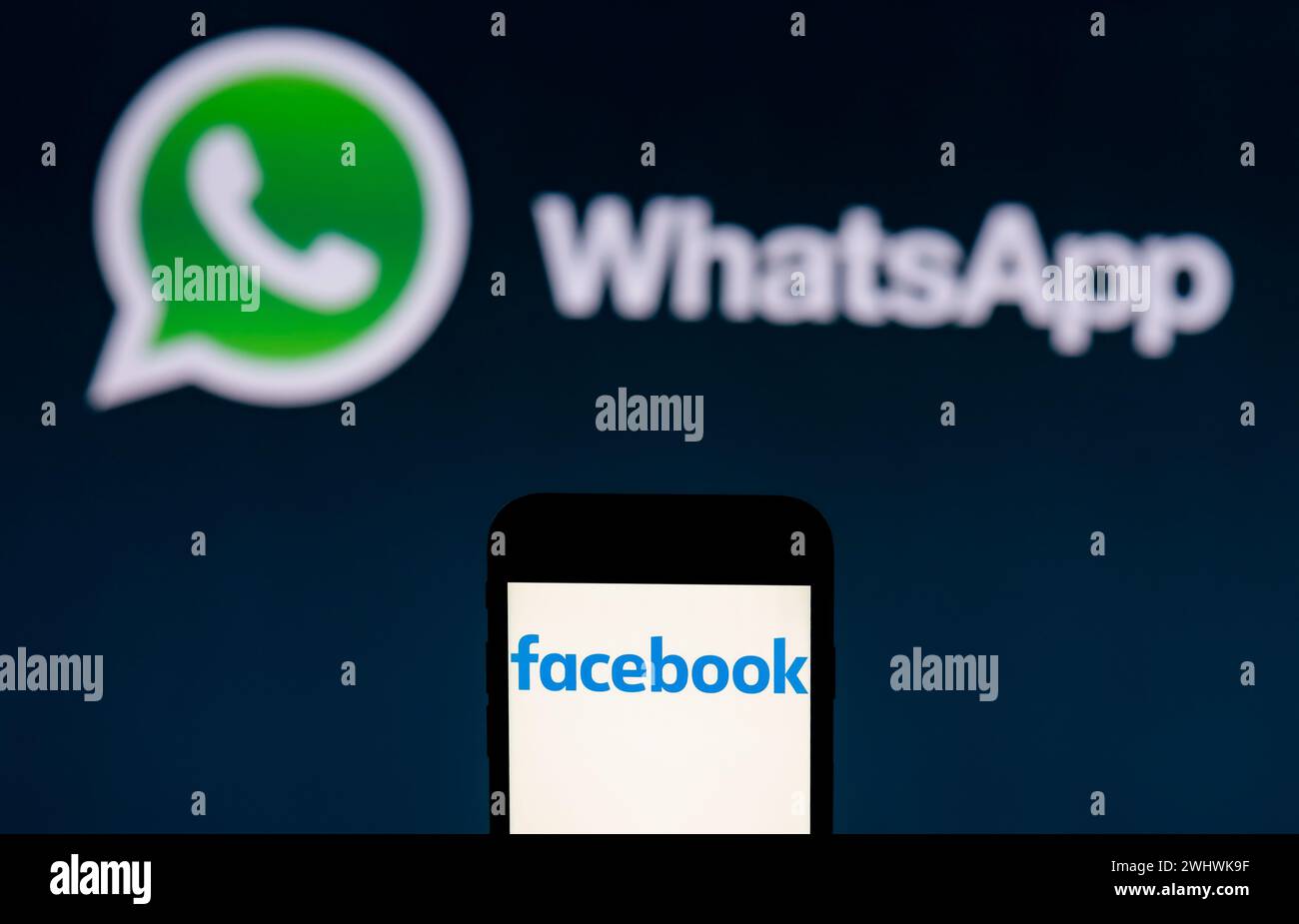 India. 12th Feb, 2024. In this photo illustration, the Facebook logo is seen displayed on a mobile phone screen with WhatsApp logo in the background. (Photo by Idrees Abbas/SOPA Images/Sipa USA) *** Strictly for editorial news purposes only *** Credit: Sipa USA/Alamy Live News Stock Photo