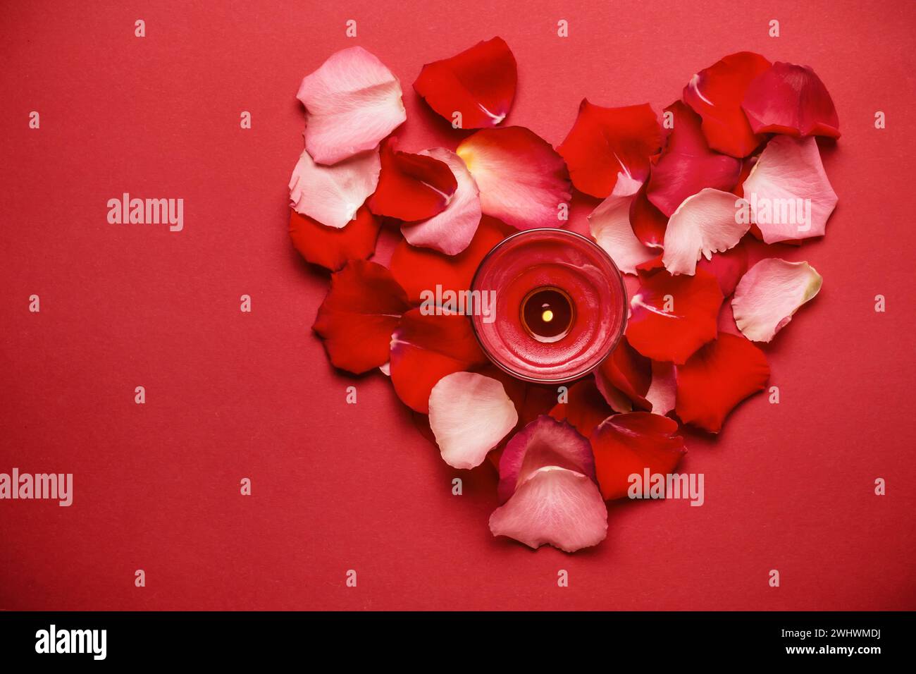 Love is a romantic concept. Heart of rose petals and candle Stock Photo ...