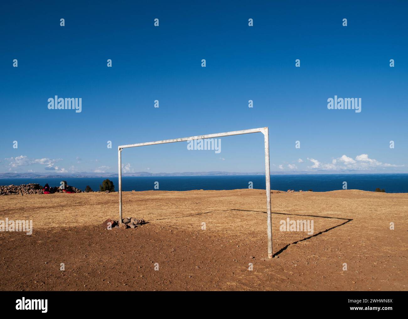 Landscape photograph on Amantani Island of a soccer goal on a sand field with Lake Titicaca in the background, Peru Stock Photo