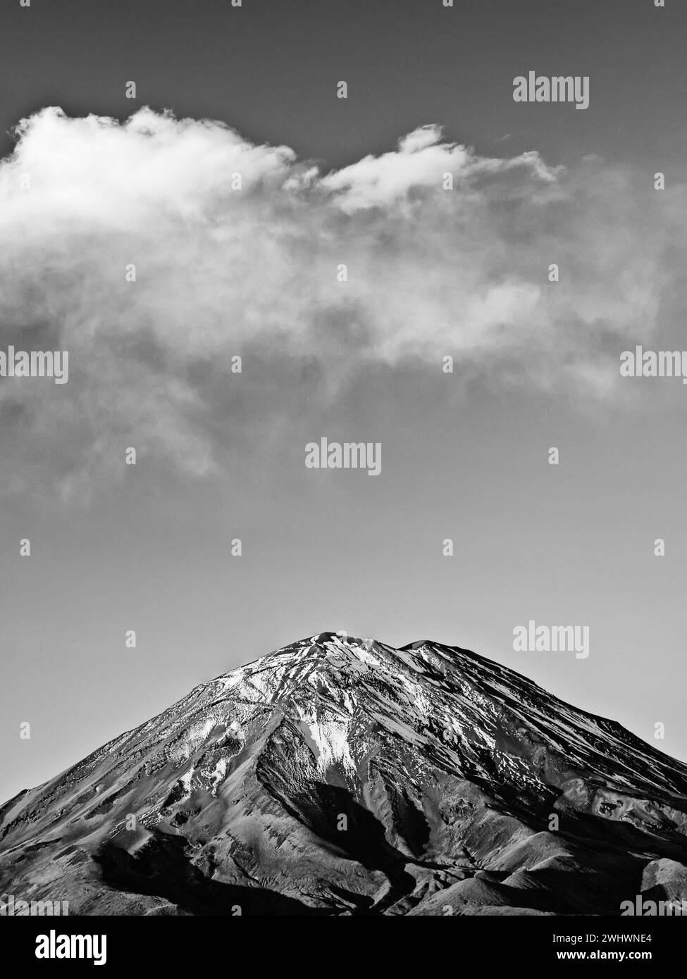 Black and white photograph of the snow-capped Peruvian volcano Misti from the town of Arequipa with clouds above. Peru. Stock Photo