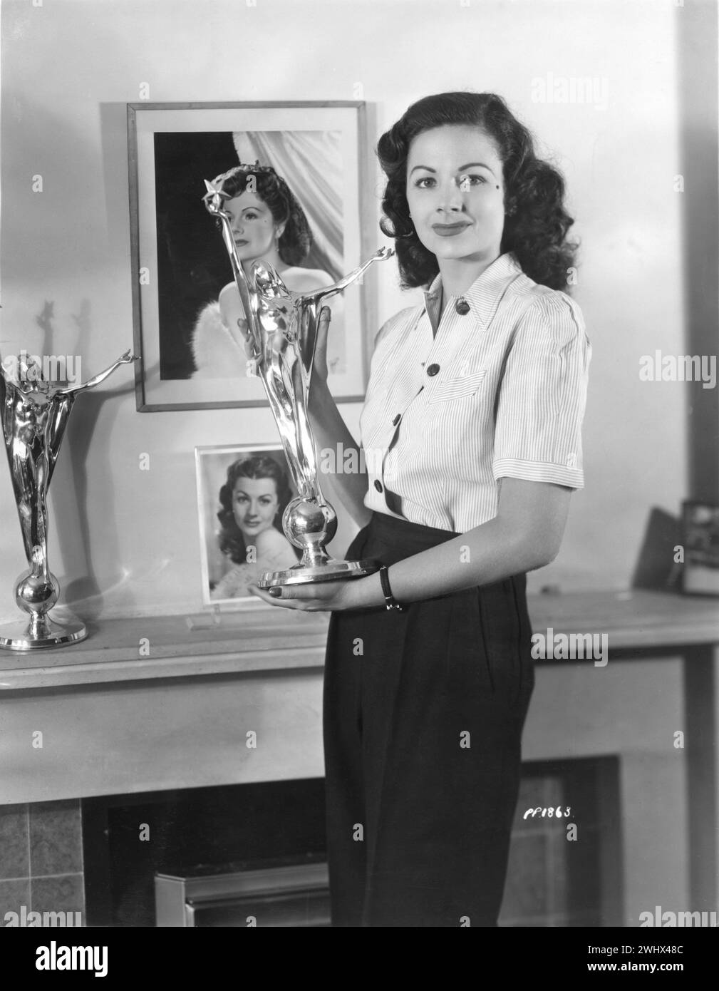 British Film Actress MARGARET LOCKWOOD holding her Daily Mail Film Award as Best Actress of the Year 1947 inside her flat in Roehampton, Southwest London. On the mantelpiece is the trophy she won the previous year in 1946 for Most Outstanding Actress During The War Years Rank Films Publicity Stock Photo