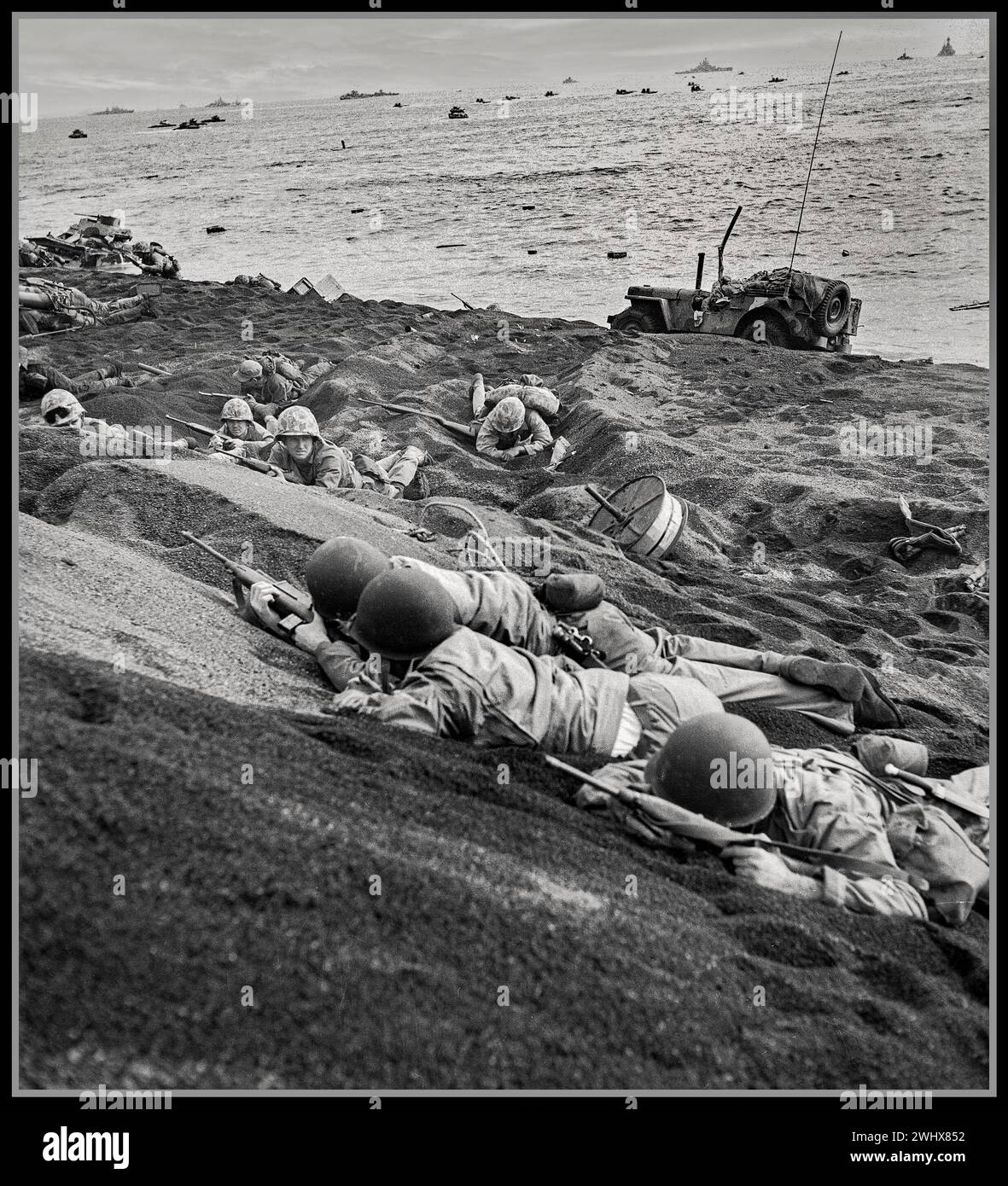 WW2 Battle of Iwo Jima. American Marines take cover under heavy fire from Imperial Japan Forces on the beach. The Battle of Iwo Jima was a major battle in which the United States Marine Corps and United States Navy landed on and eventually captured the island of Iwo Jima from the Imperial Japanese Army during World War II. Stock Photo