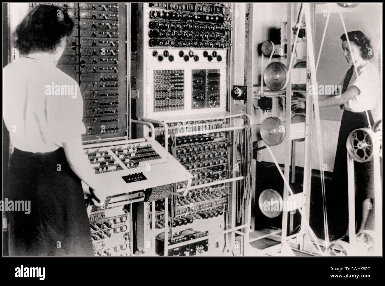 WW2 CODEBREAKING COMPUTER Colossus Mark 2 codebreaking computer being operated by Dorothy Du Boisson (left) and Elsie Booker (right), 1943 Colossus reduced time to work out Lorenz chi-wheel settings and enabled more messages to be deciphered and the whole code-breaking operation accelerated. The information gleaned from the decrypted messages is widely acknowledged to have shortened the war by many months, saving thousands of lives. Colossus Mark 2  used shift registers to quintuple the processing speed, first worked on 1 June 1944, just in time for Normandy landings on D-Day Stock Photo