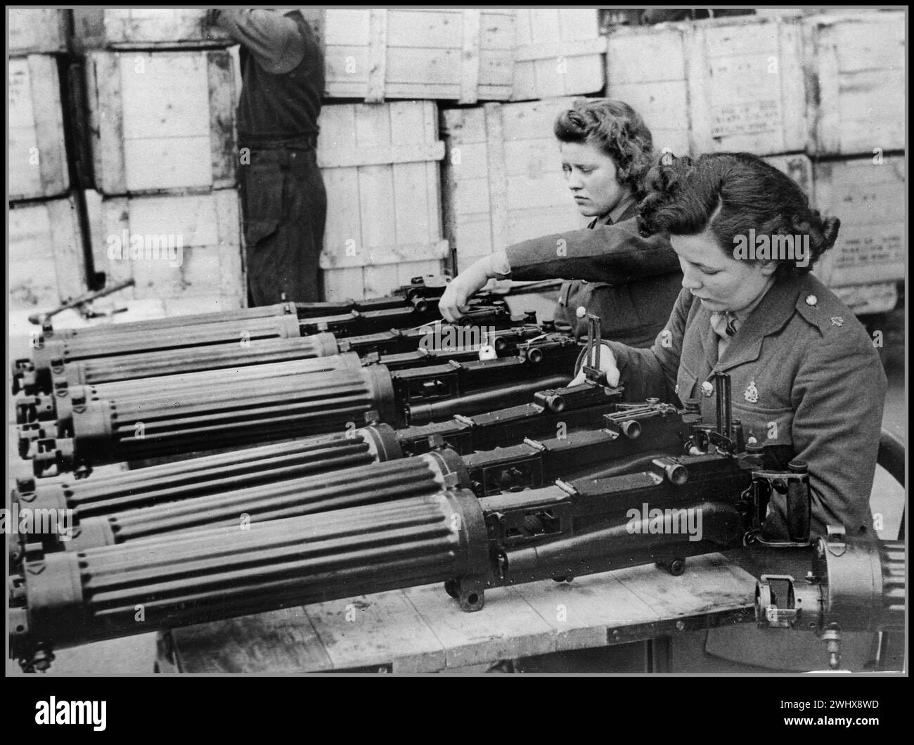 WW2 UK War Work Water-cooled .303 Vickers machine guns just arrived from Vickers Ltd. are checked at an ordnance depot in England by women of the ATS World War II Second World War Date circa 1941 Stock Photo