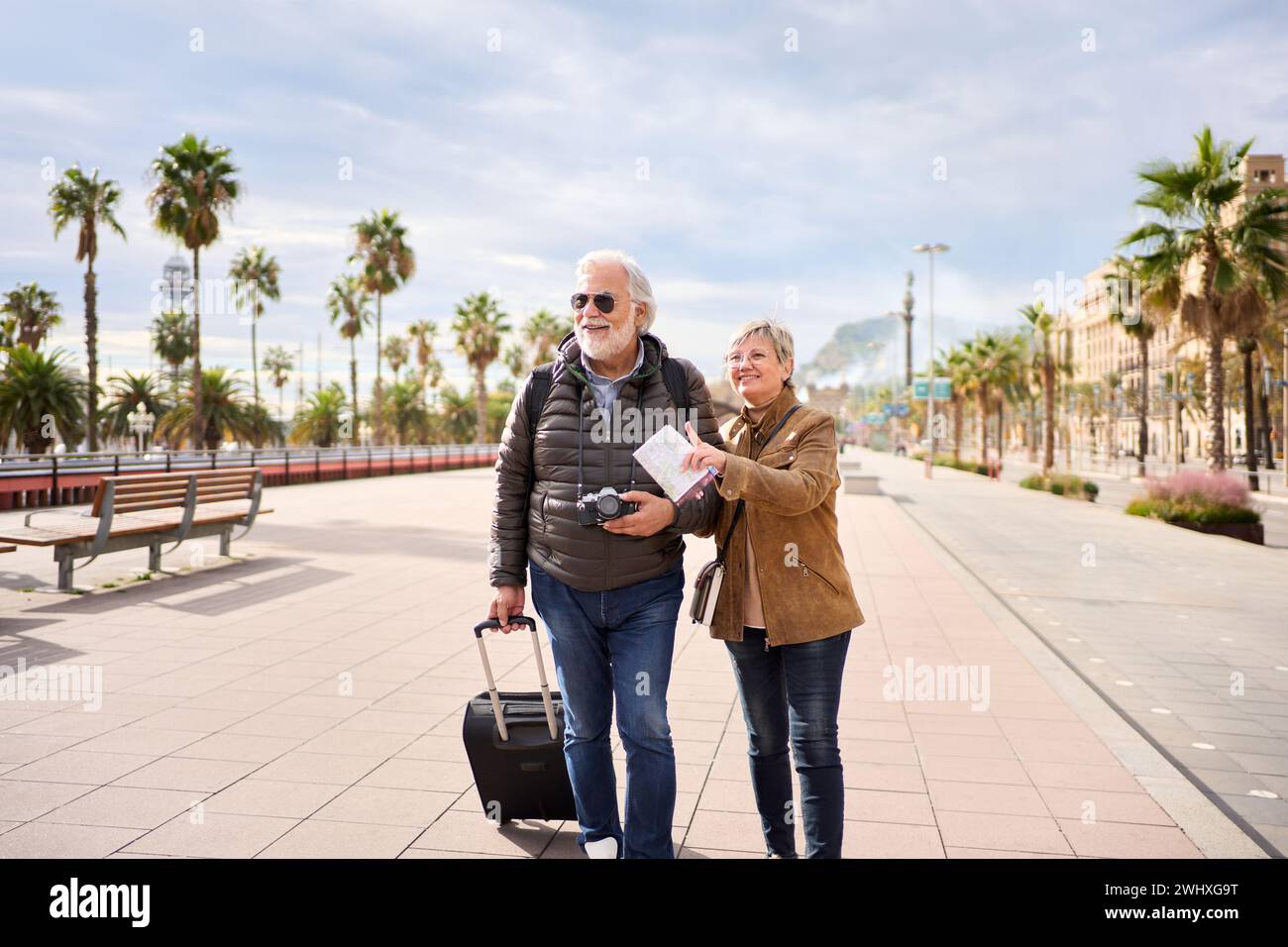 Older Caucasian tourist couple smiling looking and pointing interest places. Senior tourism people. Stock Photo
