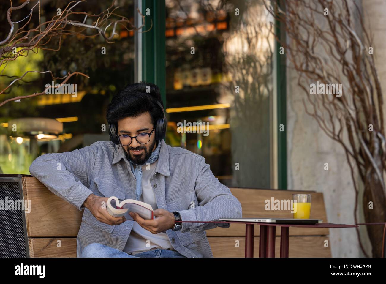 Dark-haired young hindu man in headphones with a book in hands Stock ...