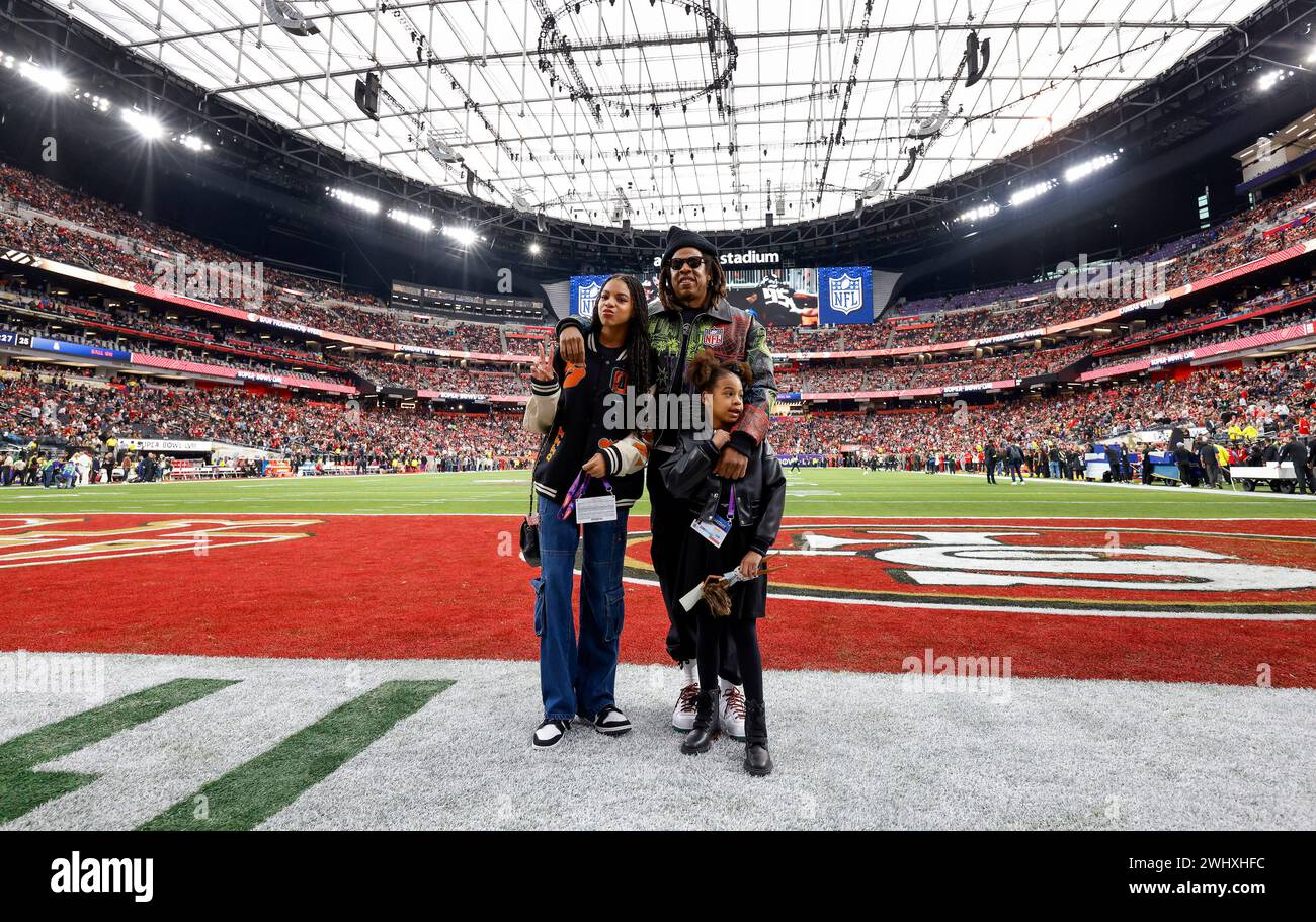 Entertainer Jay-Z and two of his daughters walk onto the field before